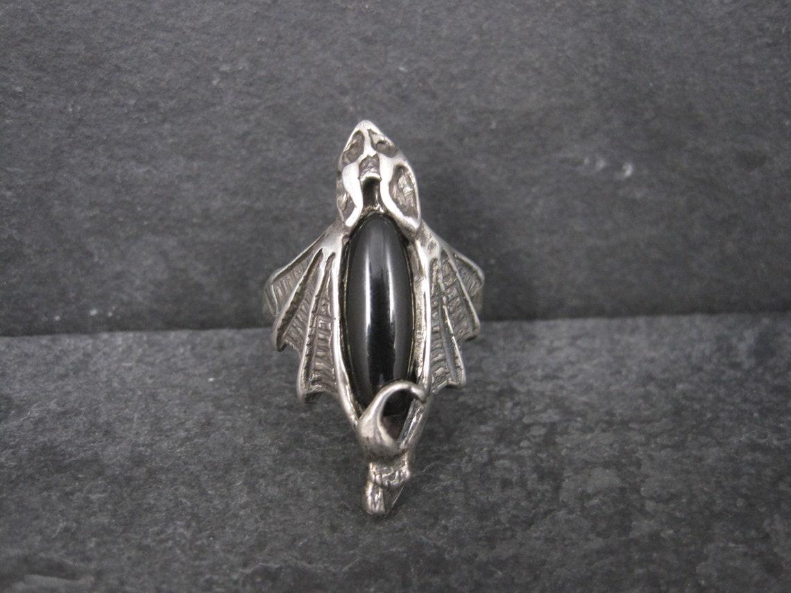 This gorgeous vampire bat ring is solid sterling silver and features a genuine onyx stone.
Its a heavy, well made piece.

The face of this ring measures 1 1/2 inches north to south! It is definitely a statement.
Size: 12

Marks: None - verified as