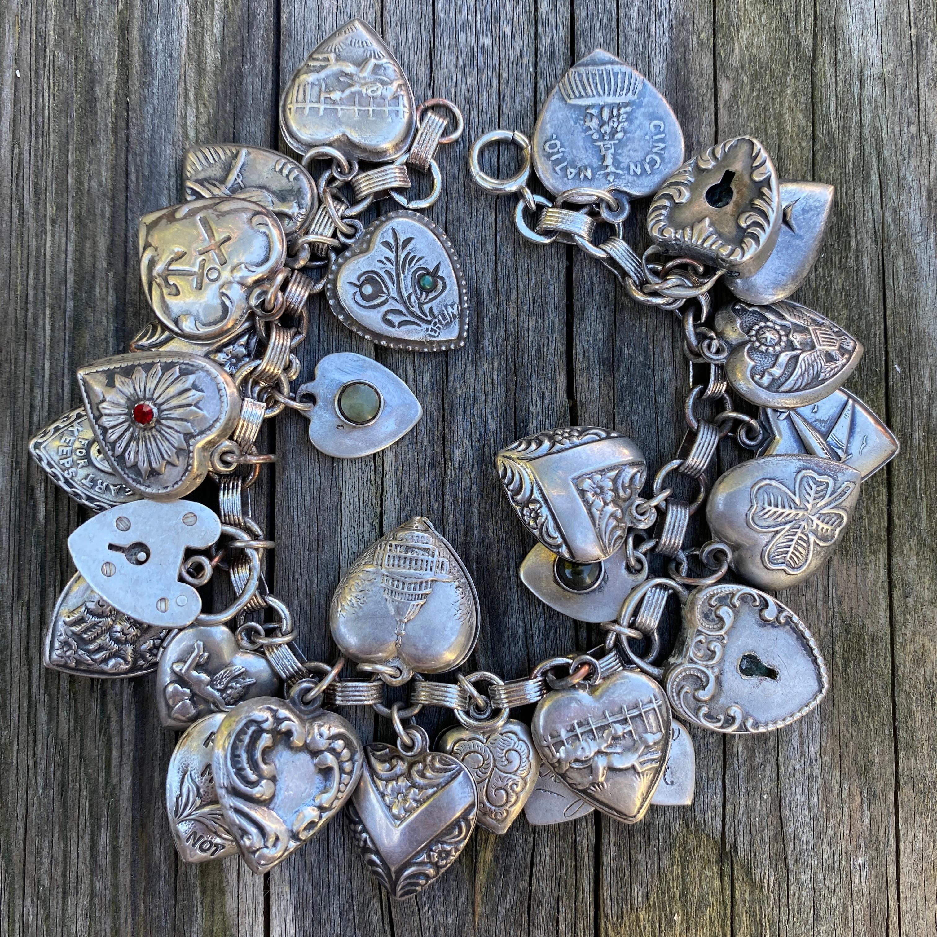 Details:
Fantastic 1900-1940's vintage charm bracelet with puffy heart charms. Great collection of 28 puffy hearts, three sweet heart locks, three dog charms, a forget me not, cupid, airplane, for sweet engraved named hearts—Earnie, Doug, Lola,