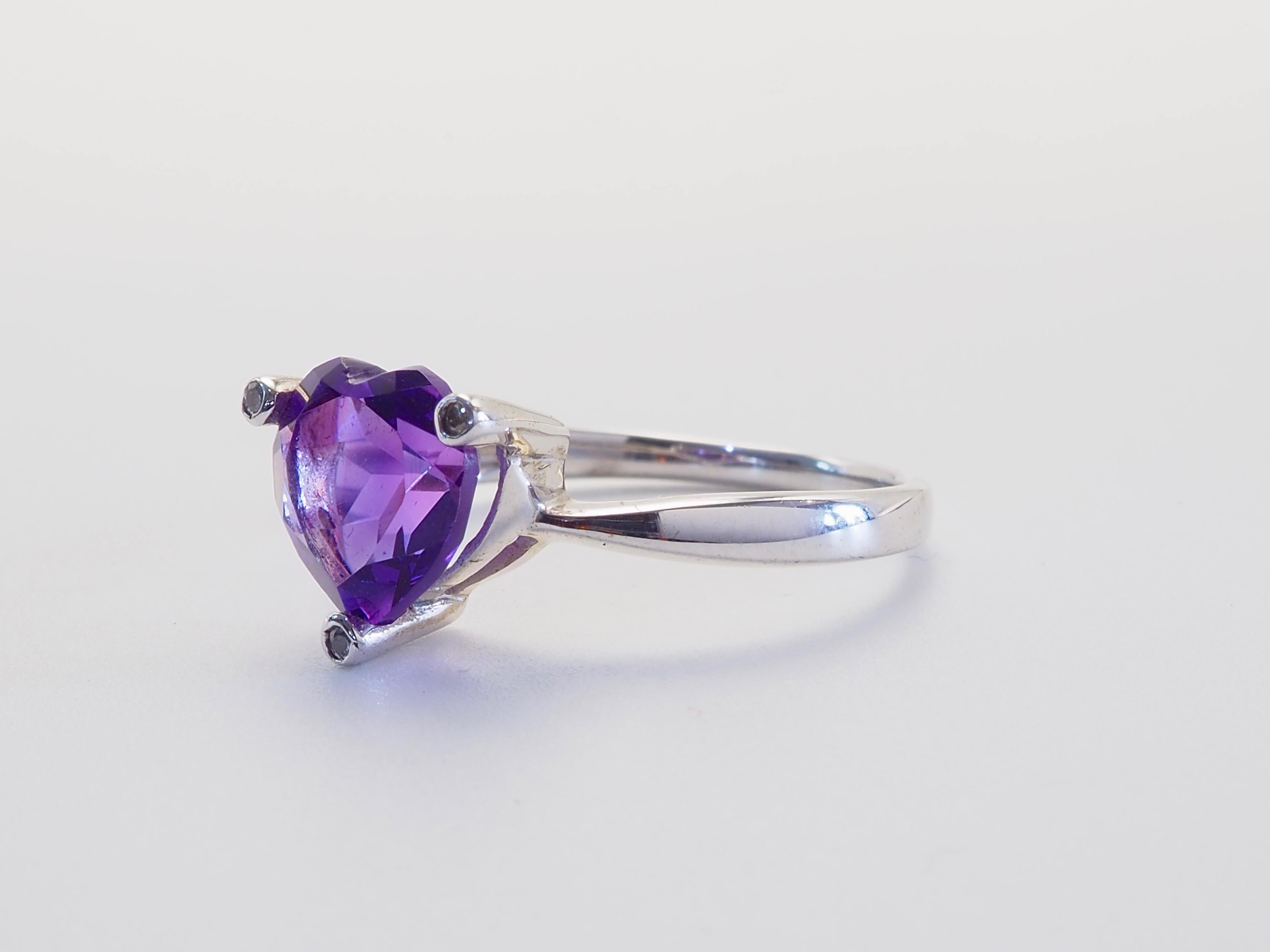 Ein romantisches Fest der Farben und der Handwerkskunst ist dieser feine Ring mit einem leuchtenden 2,4-karätigen Amethysten im Herzschliff, der elegant in einer Fassung aus poliertem Sterlingsilber liegt. Der satte violette Farbton des Mittelsteins