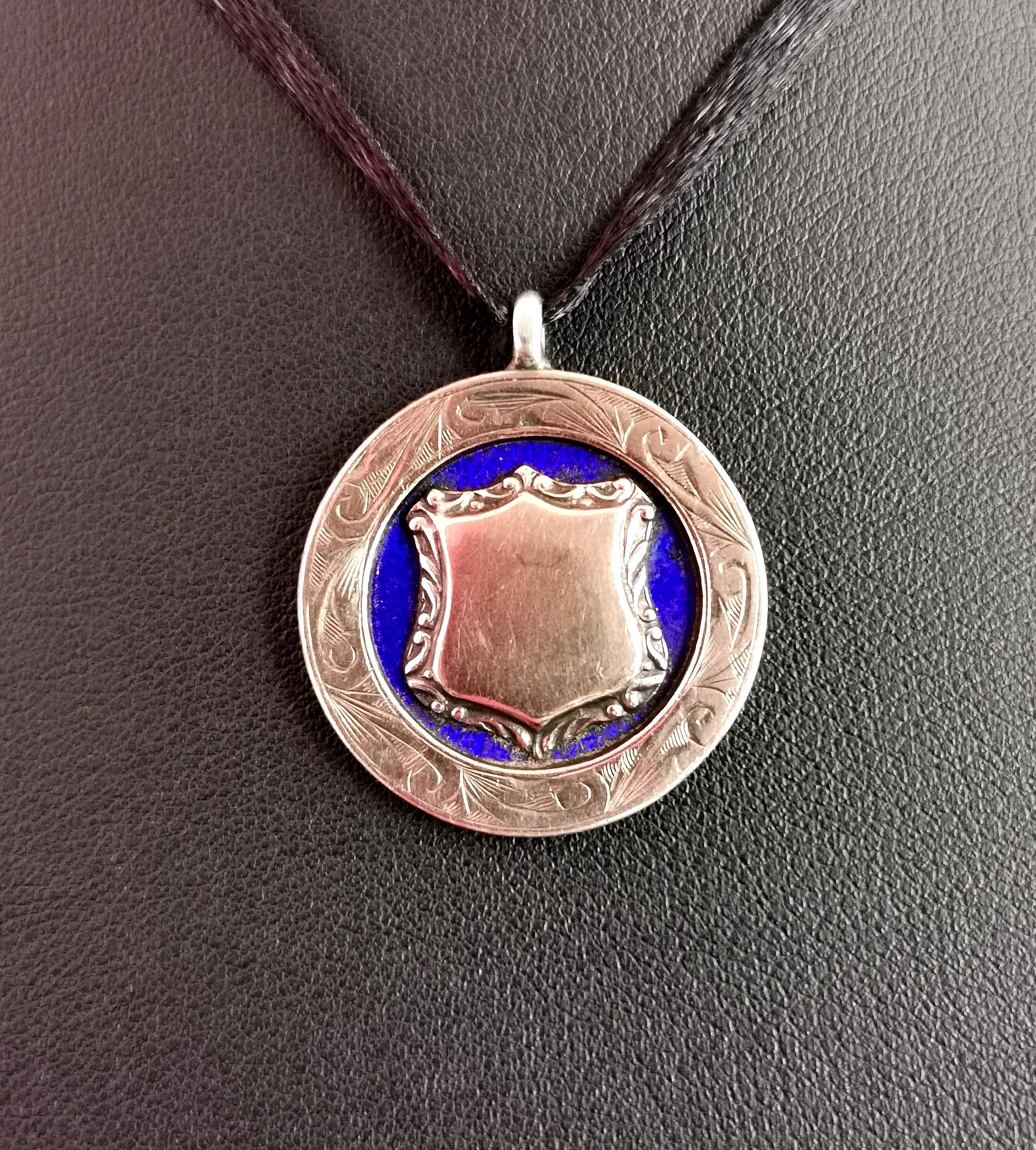 An attractive vintage, 1920's sterling silver, cobalt blue enamel and Rose gold plated fob pendant.

A decorative fob with a rose gold plated outer rim which is lightly engraved surrounding a rich cobalt blue guilloche enamel.

To the centre there