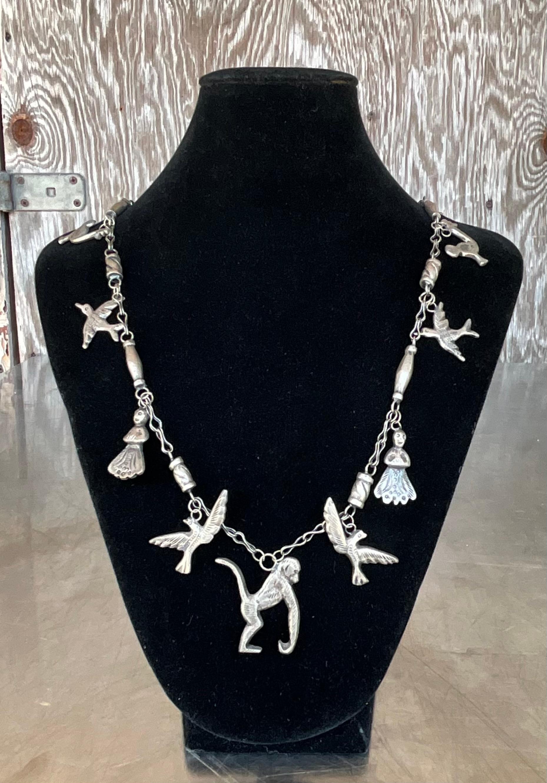 Questa collana vintage in argento sterling con animali africani è un omaggio alla fauna e all'arte del continente africano. Realizzato in vero argento sterling, ogni ciondolo o pendente della collana mostra una rappresentazione finemente dettagliata