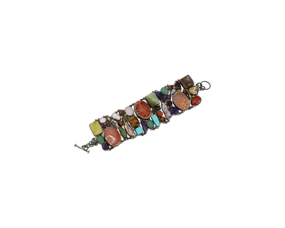 A Mexican 925 Sterling Silver bracelet. The bracelet is made in an Ethnic design, and encrusted with semi precious stones in various shapes and sizes. Marked with a Mexico mark, and a standard Sterling Silver hallmark, on the backside. Overall
