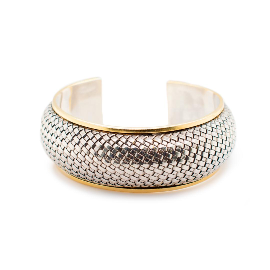 One lady's custom made brush finished, textured, silver and 14K yellow gold, vintage, cuff bracelet. The bracelet measures approximately 7.00 inches in length and weighs a total of 52.68 grams. Engraved with 