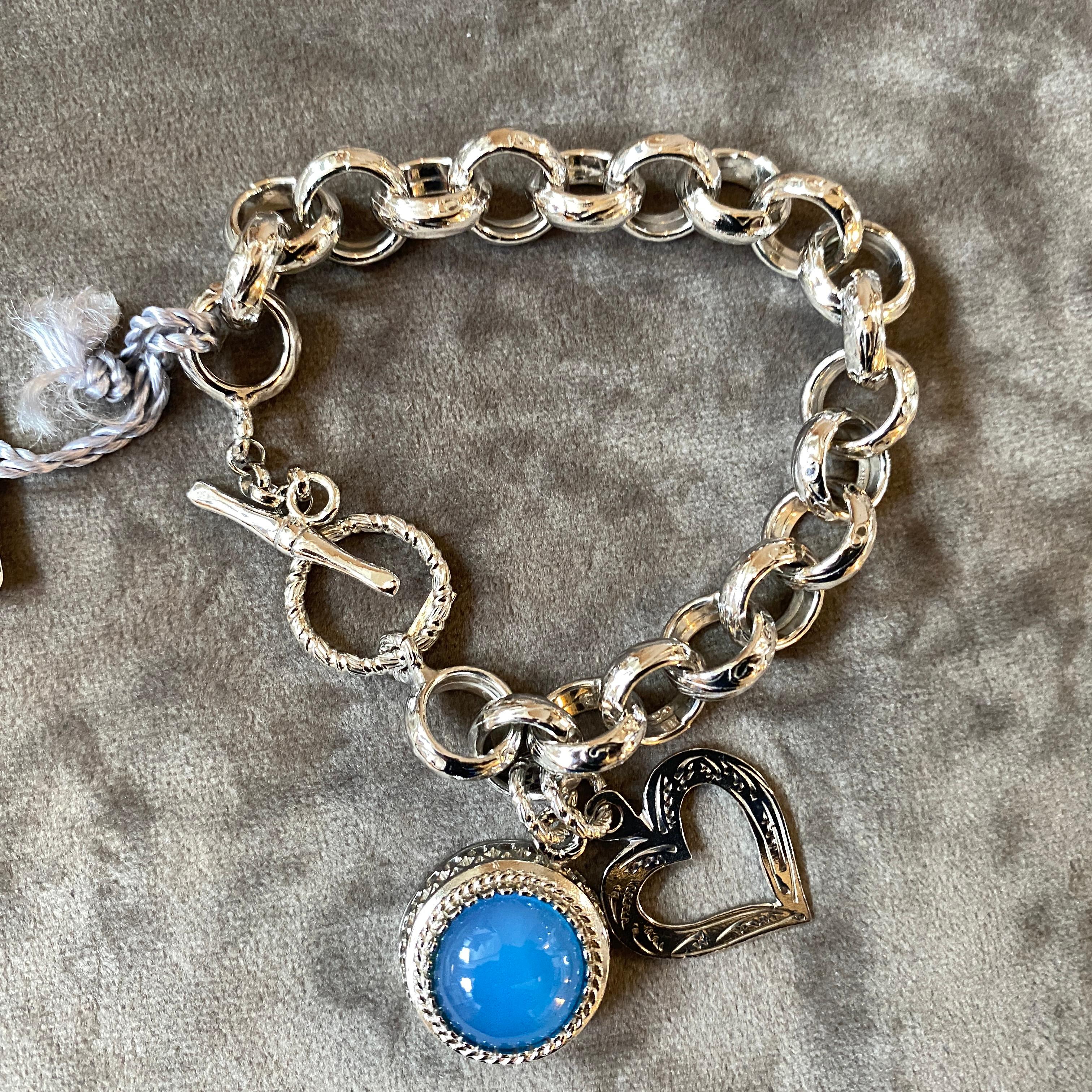 A sterling silver bracelet made in Italy in the Nineties hand-worked as a jewel. Blue Cabochon agate  and a sterling silver heart pendant in an hand-crafted chain. The 1990s Vintage Sterling Silver and Blue Agate Pendant Italian Bracelet by Anomis