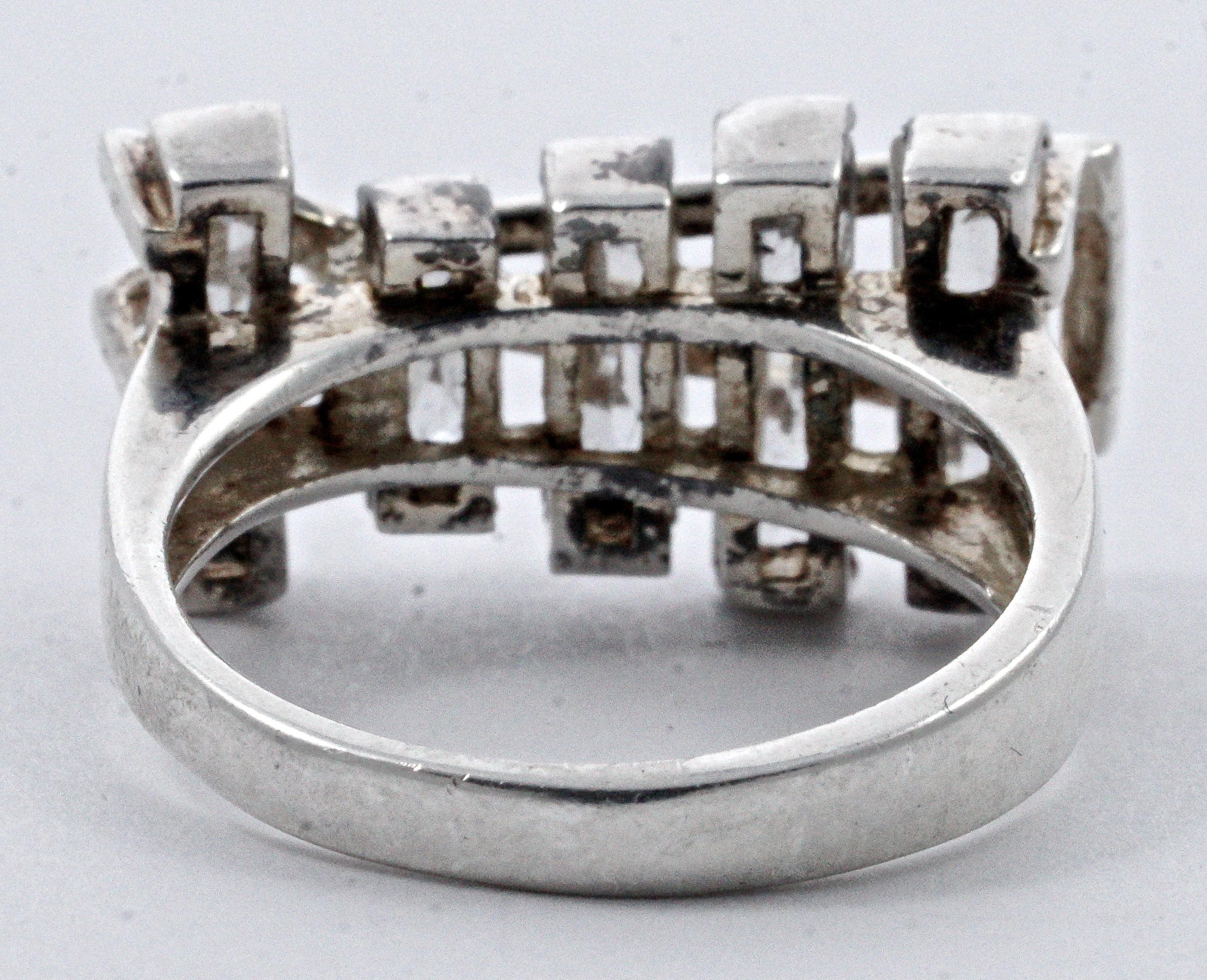 Stylish sterling silver geometric design ring featuring five faceted clear baguette stones. Ring size UK O / US 7, inside diameter 1.8cm / .71 inch. The front measures length 2.3cm / .9 inch by maximum width 1.2cm / .47 inch, and the setting depth