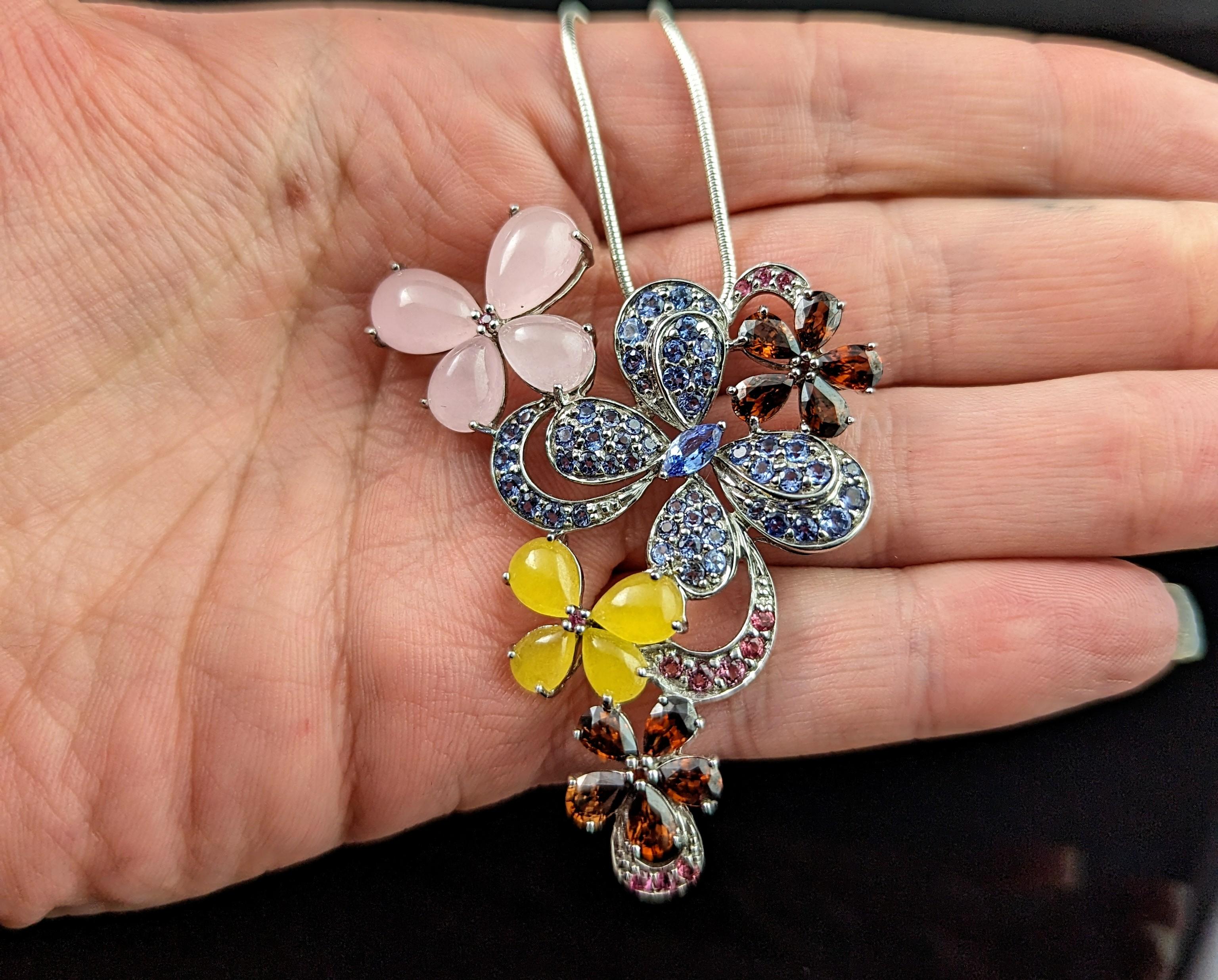 This vintage sterling silver and gem set pendant is so pretty and the perfect piece for the warmer sunny months.

Crafted in cool sterling silver it has variously designed butterflies and flowers set with an array of colourful gemstones including