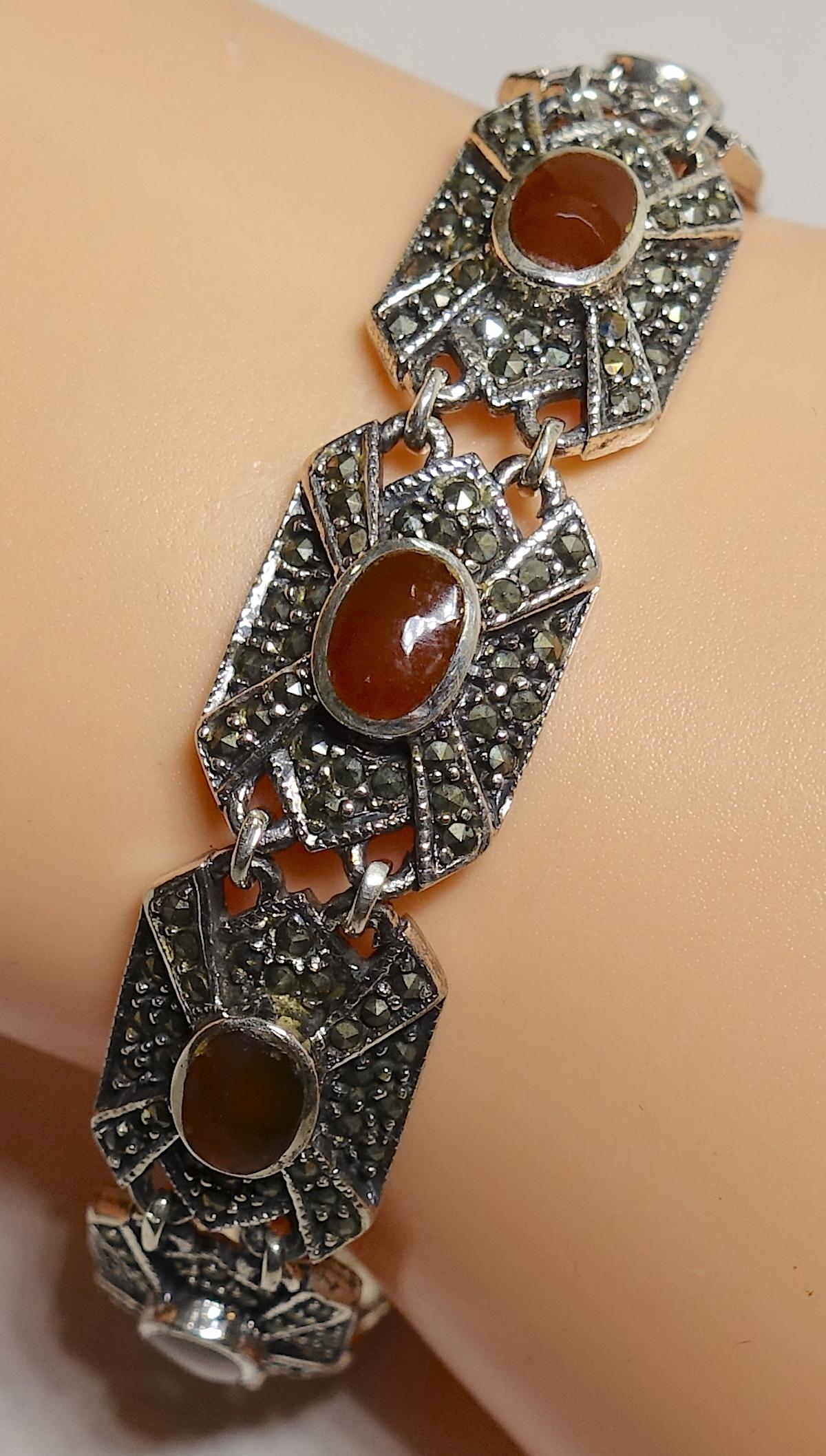 This vintage bracelet has 7 links … each with a carnelian cabochon center surrounded by marcasites … set in sterling silver.   In excellent condition, this bracelet measures 7-1/2” x 1/2” with a fold-over clasp with a safety chain.