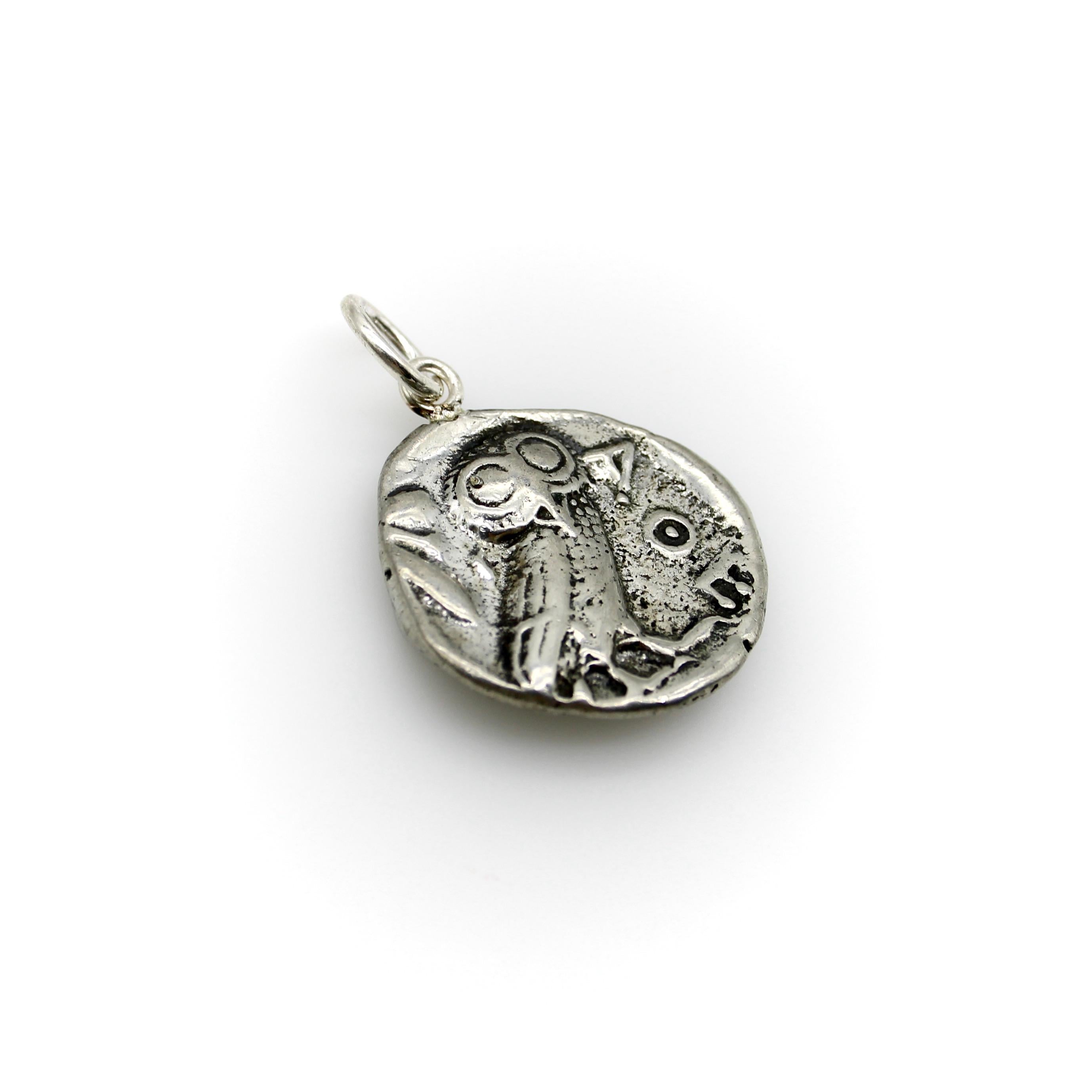 The coin featured in this pendant is famously reproduced because of its striking image of an owl. The coin originally dates to 440-400 B.C. and comes from Ancient Greece. The owl has big eyes, and we can see why people find this coin so charming.