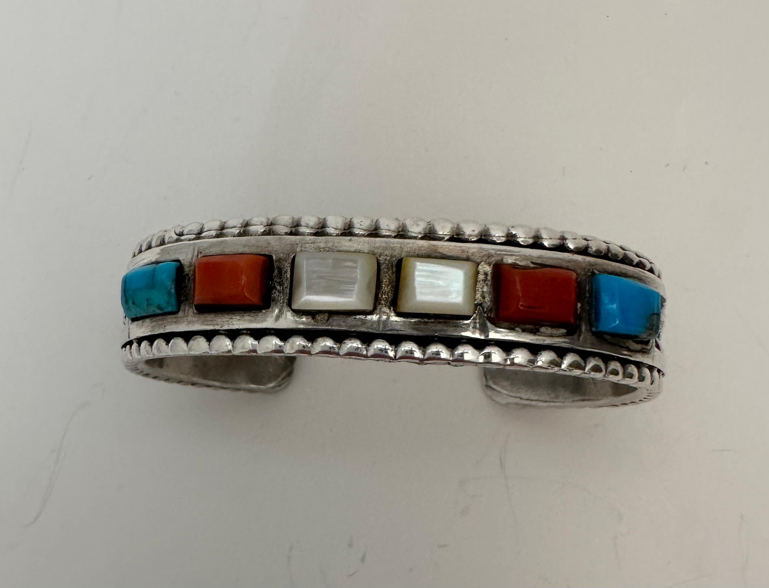 Vintage Navajo Sterling Silber .925 Koralle, Türkis und Perlmutt Inlay kleine Manschette Armband
Ungefähr: 1/2