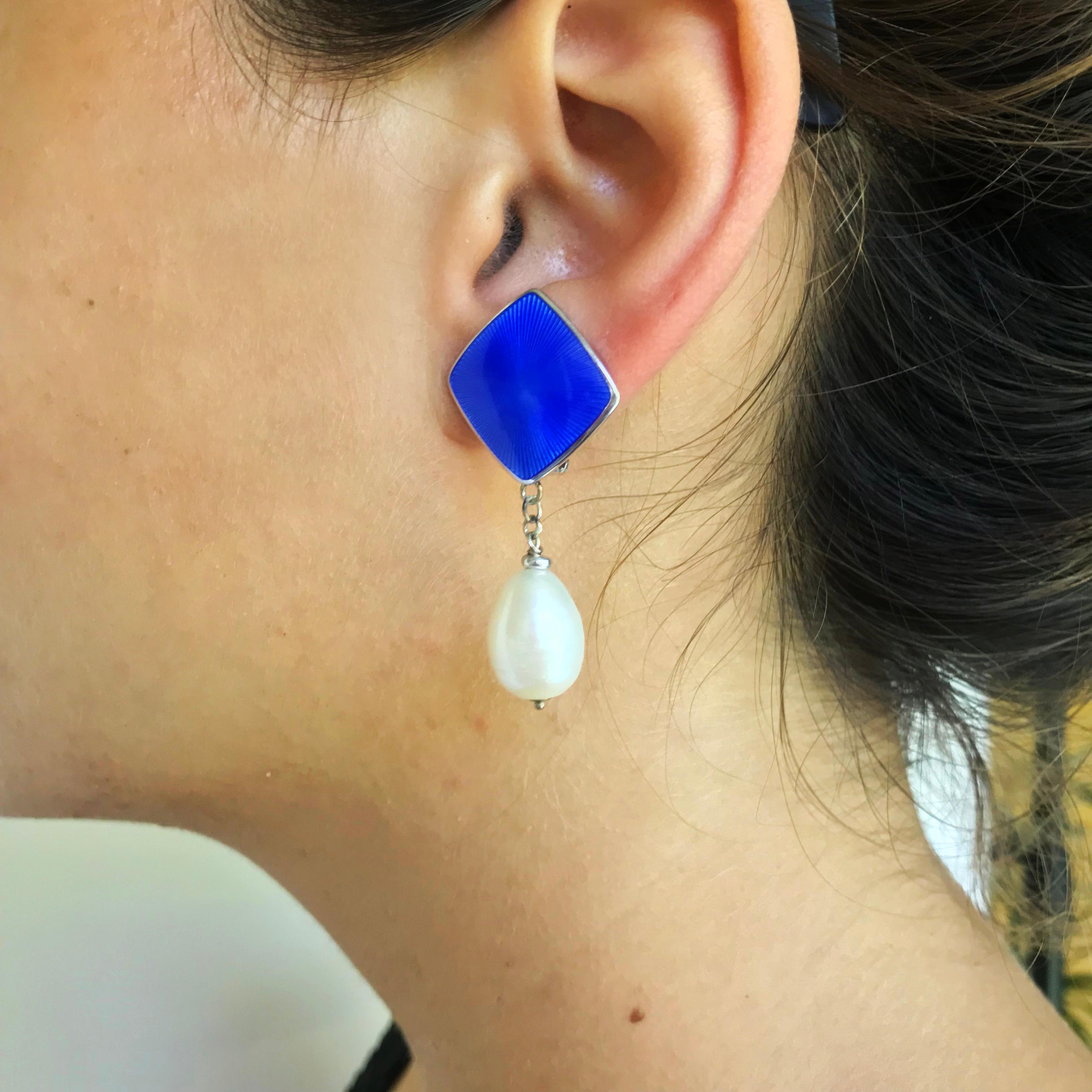 Marina J. presents a beautiful clip-on earring design, made of a vintage sterling silver white gold plated enamel and white pearls. This unique piece is shaped like a diamond and drops a beautiful big white pearl that sways with your steps. The