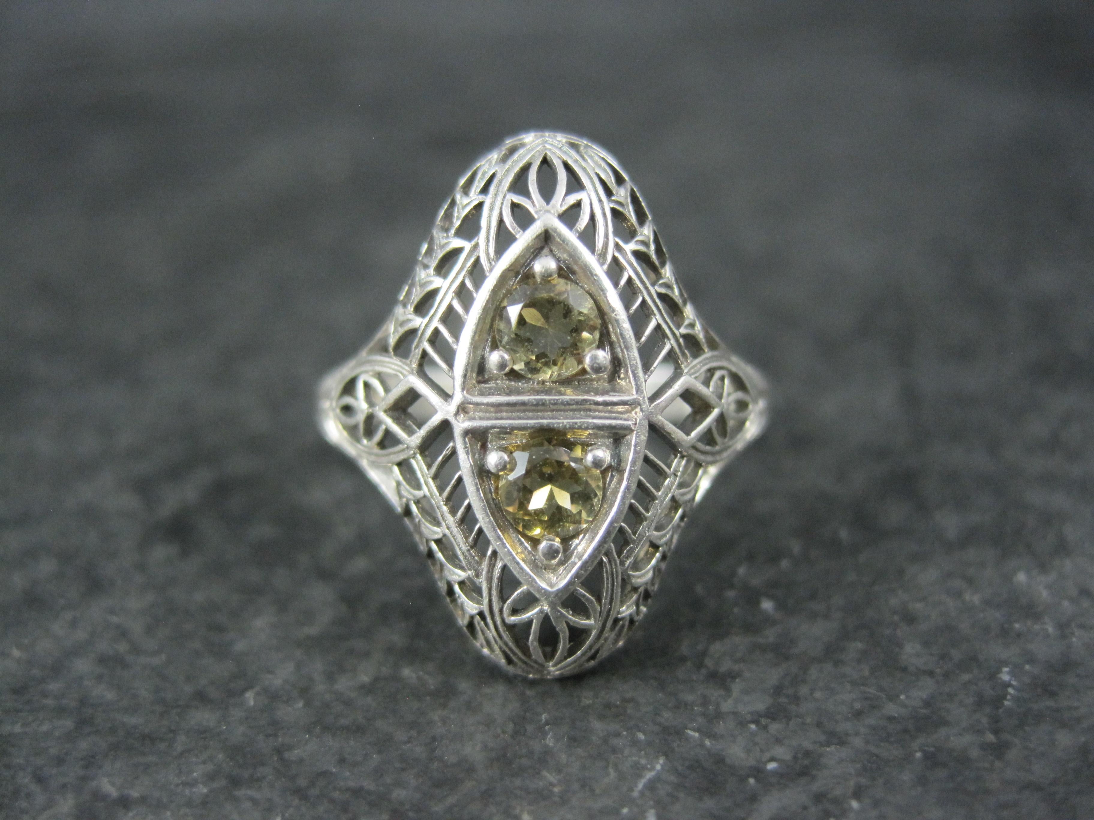 Questo bellissimo anello è una riproduzione Art Deco d'epoca da stampi originali.
È in argento sterling con 2 gemme citrine rotonde di 4 mm.
La faccia di questo anello misura 13/16 di pollice da nord a sud con un rialzo di 4 mm dal dito.
Peso: 2.4