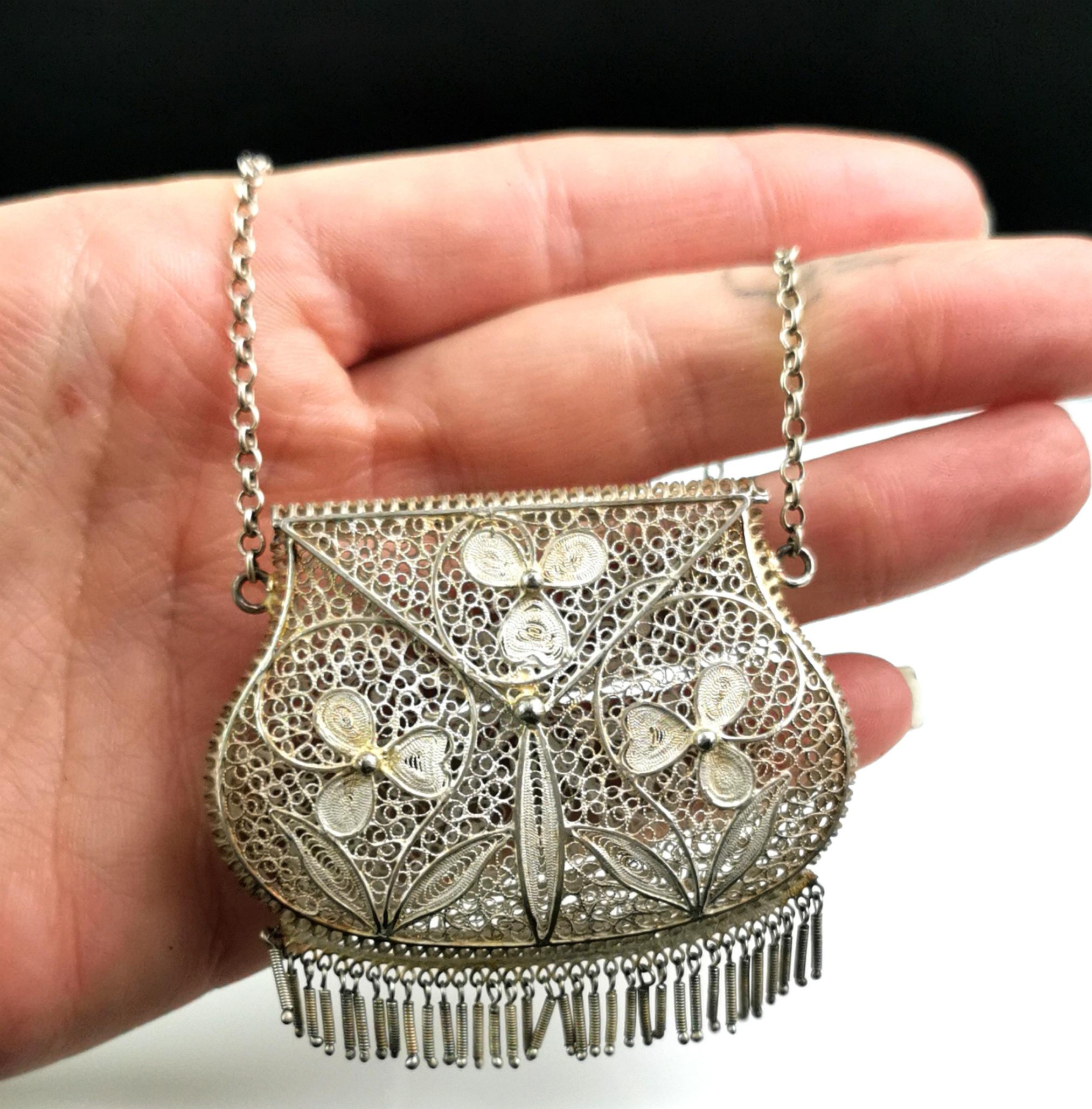 A stunning vintage Art Deco era silver evening purse.

The body is made up from intricately woven 925 sterling silver in a fascinating and eye catching filigree design.

The purse has a silver chain handle and snaps shut at the front.

It has a