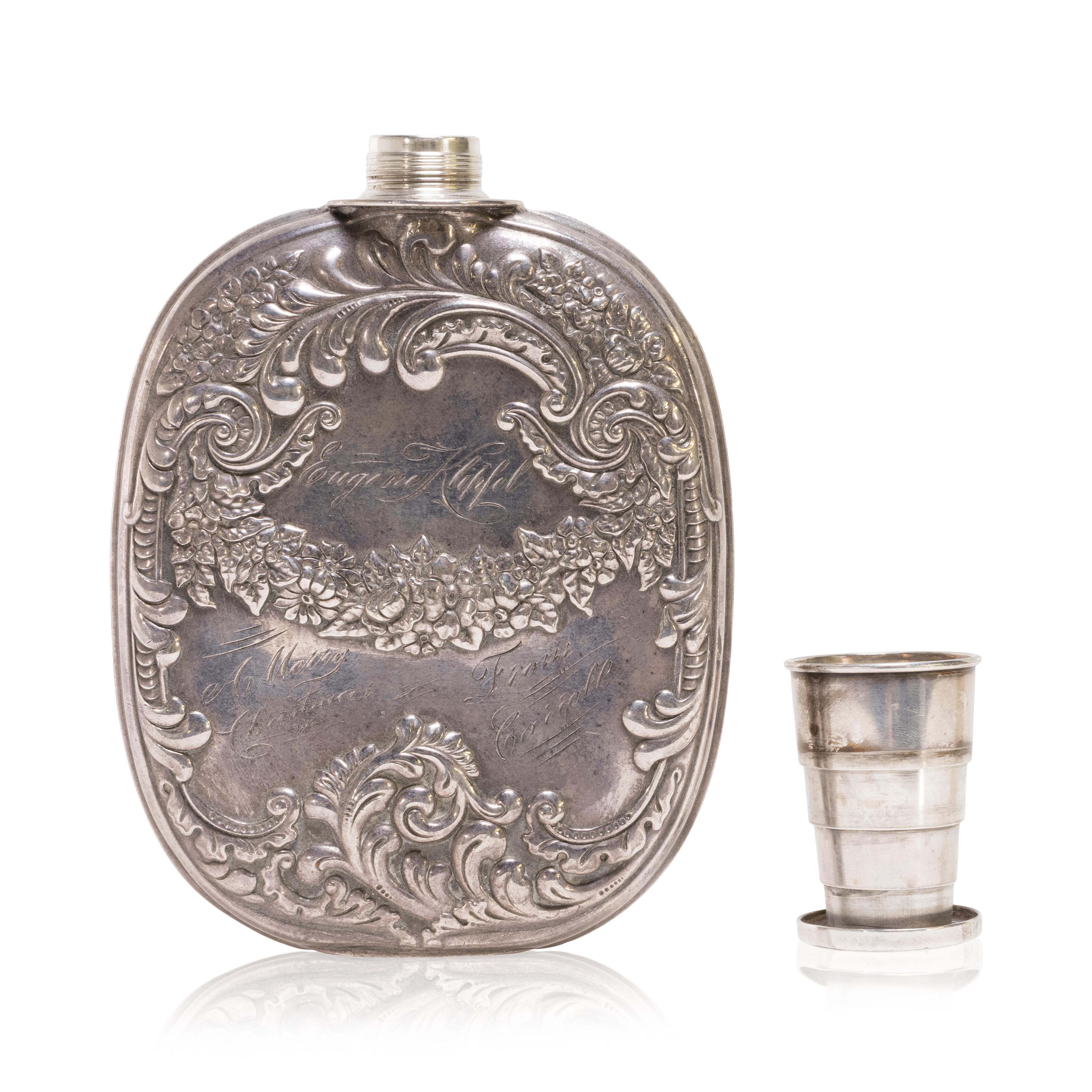 Vintage sterling silver flask with extendable shot glass lid. This wonderful flask features outstanding silver work of leaves and flowers. It has a great weight and includes an extendable shot glass. The item was once a gift to 