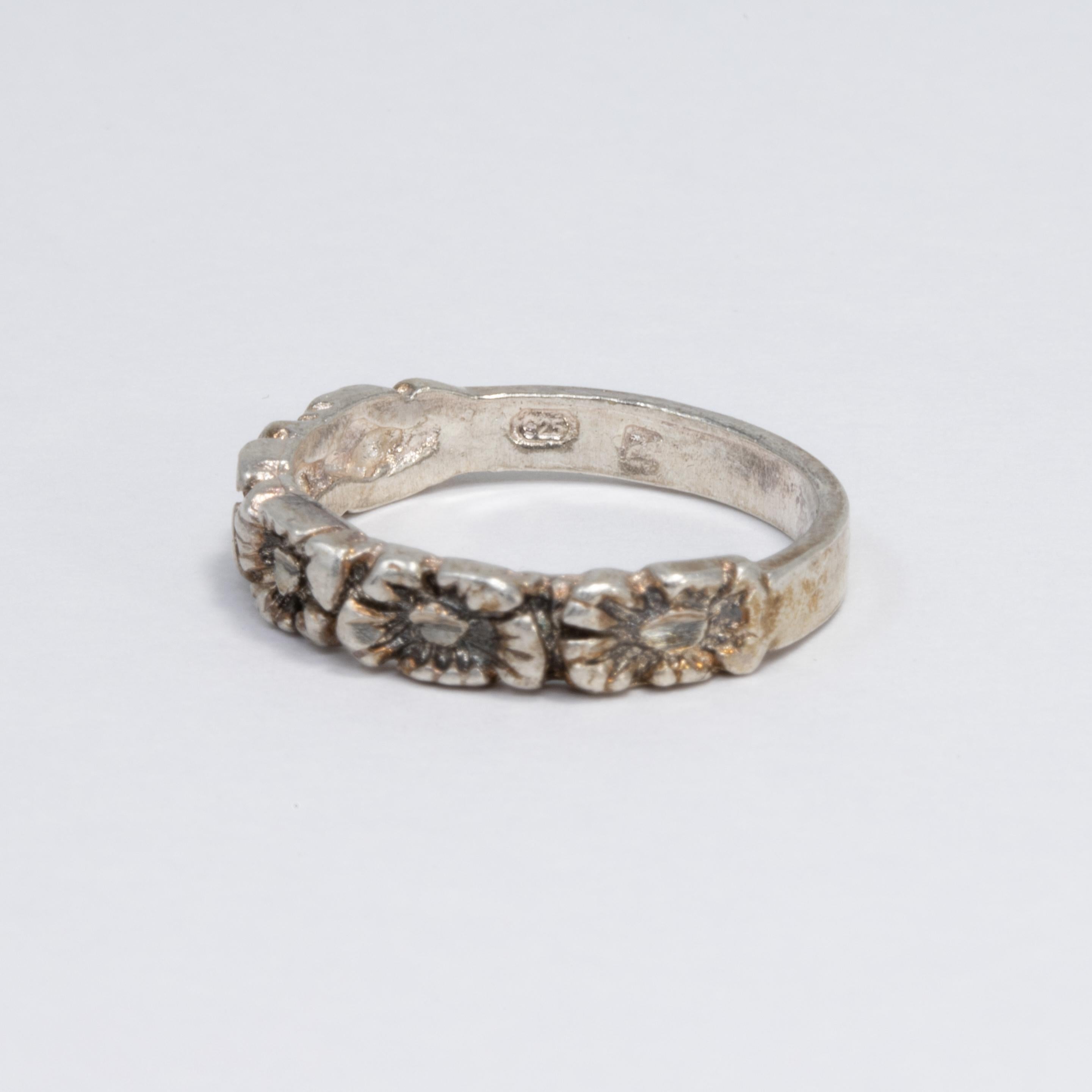 Ein wunderschöner Vintage-Ring aus Sterlingsilber, der mit einer Reihe von Blumen verziert ist.
Ring Größe US 8.5

Marken / Punzierungen / etc: 925