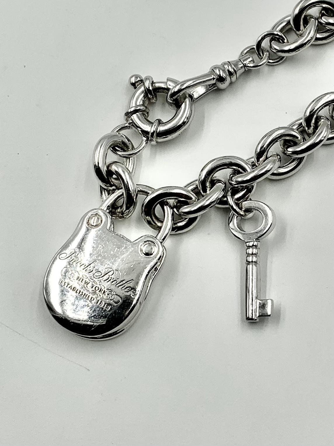 Klassisches, massives Sterling Silber, wunderbare Qualität Vintage Brooks Brothers, New York Schloss und Schlüssel Charme Armband. Das Vorhängeschloss mit eingraviertem Brooks Brothers Logo in Schreibschrift, New York, Established 1818, markiert 925