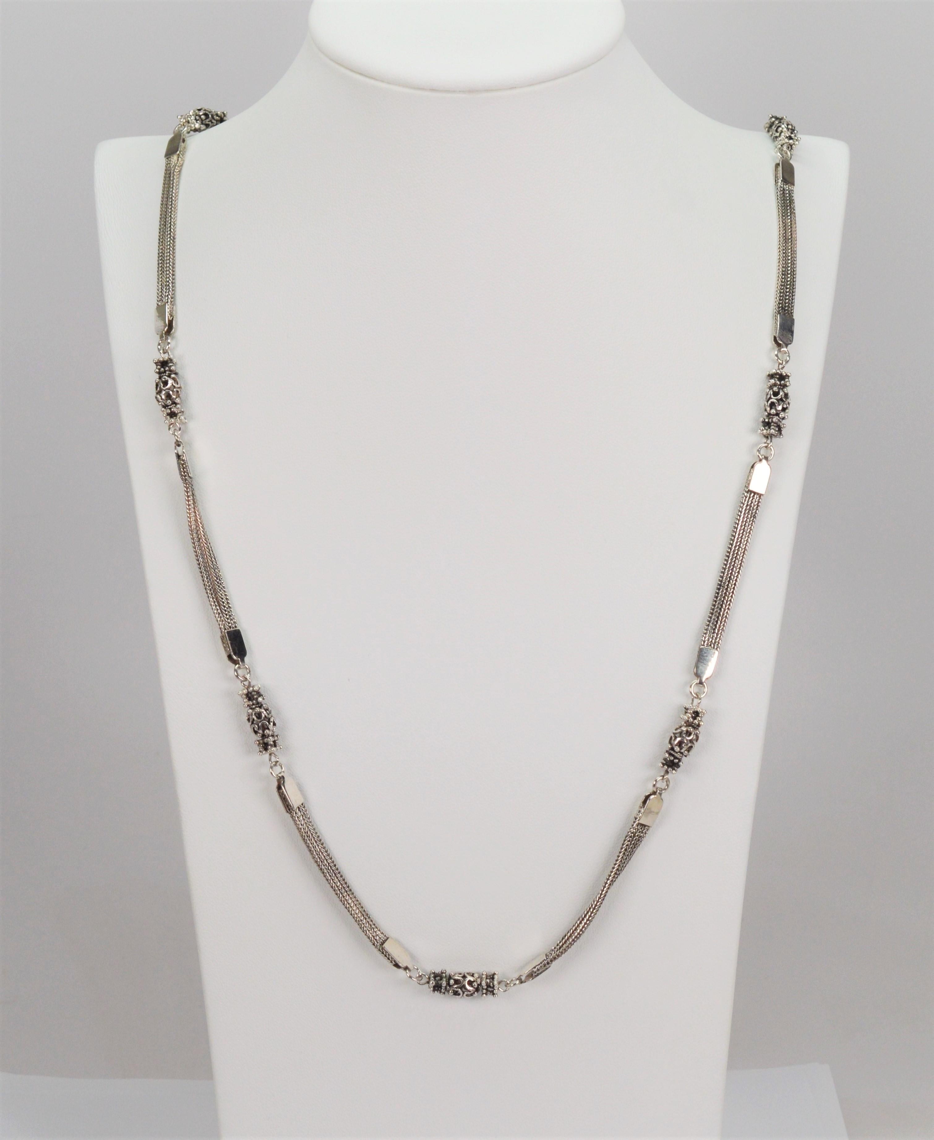 With vintage appeal, intricate sterling silver filigree beads are stationed along this interesting thirty-four inch necklace. Artful crafted by known maker Anatoli, connecting triple foxtail chain sections are each capped with silver findings and