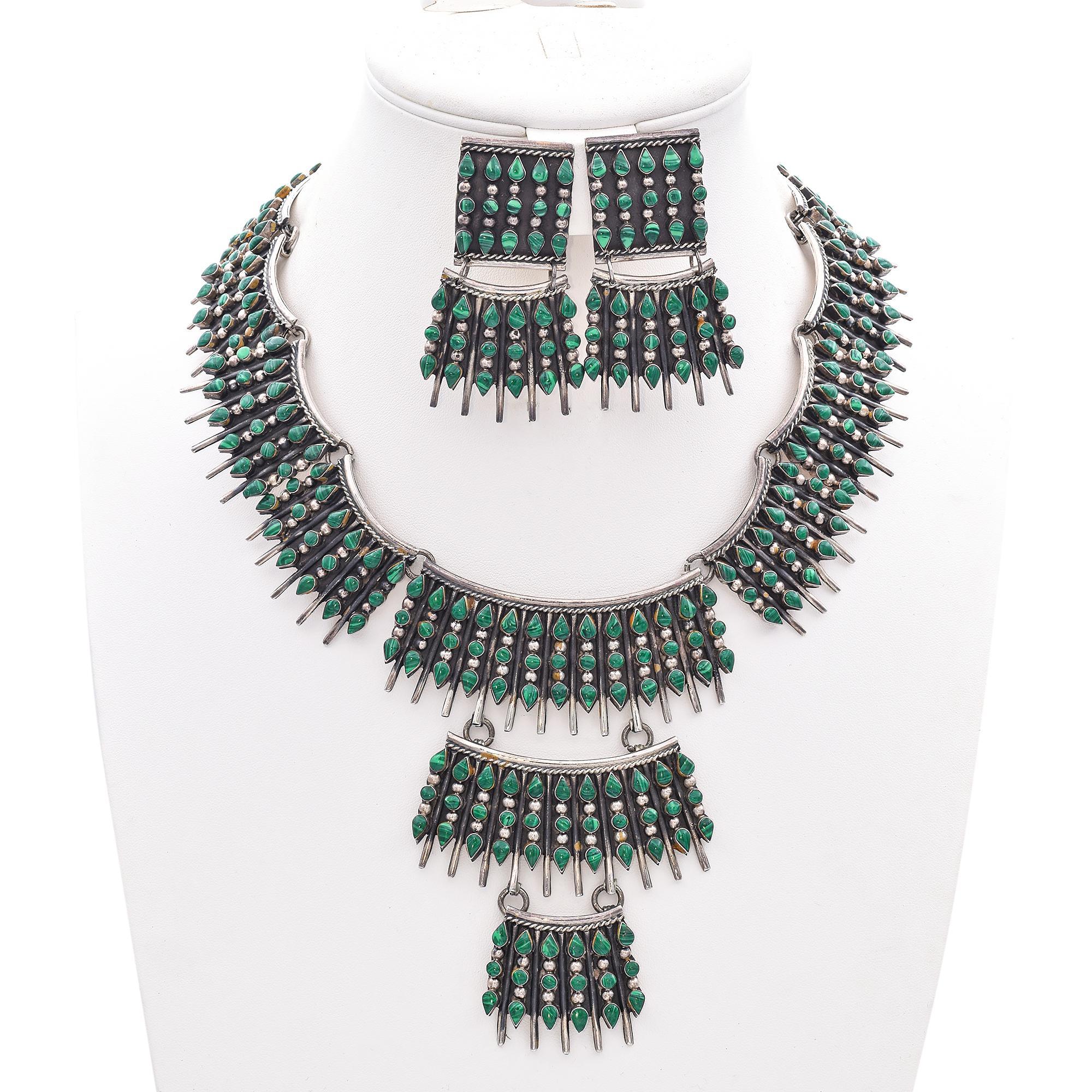L'artigianato messicano è rinomato per la sua attenzione ai dettagli e per il suo profondo legame con l'arte culturale, come è evidente in questa straordinaria parure di gioielli in malachite e argento sterling. La collana e gli orecchini sono