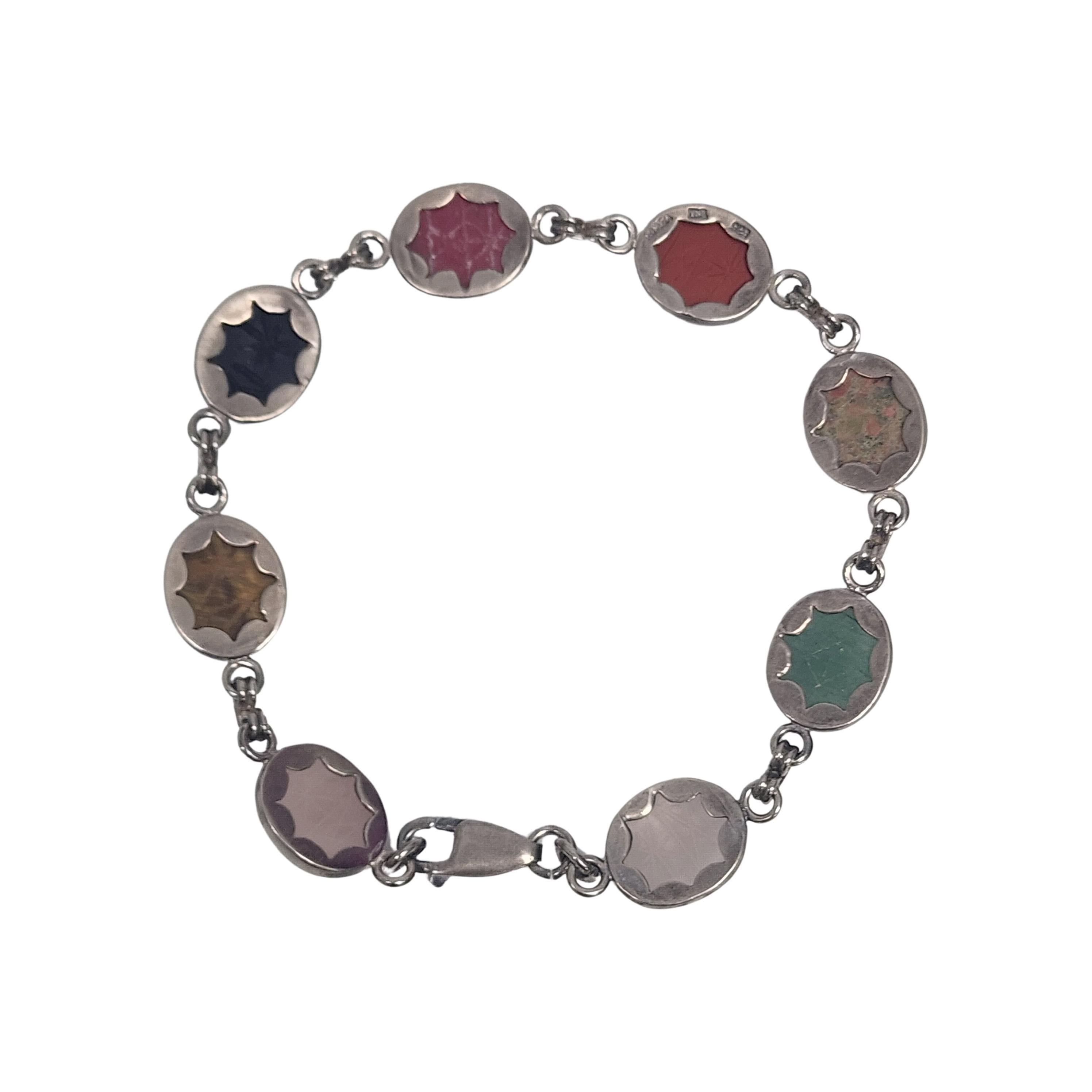 Sterling silver and multi-stone scareb bracelet.

Etched oval cabochon stones bezel set in sterling silver. Some of the stones appear to be rose quartz, tiger's eye, onyx, carnelian and jade.

Weighs approx 17.0g, 11.0dwt.

Measures approx 7 3/4