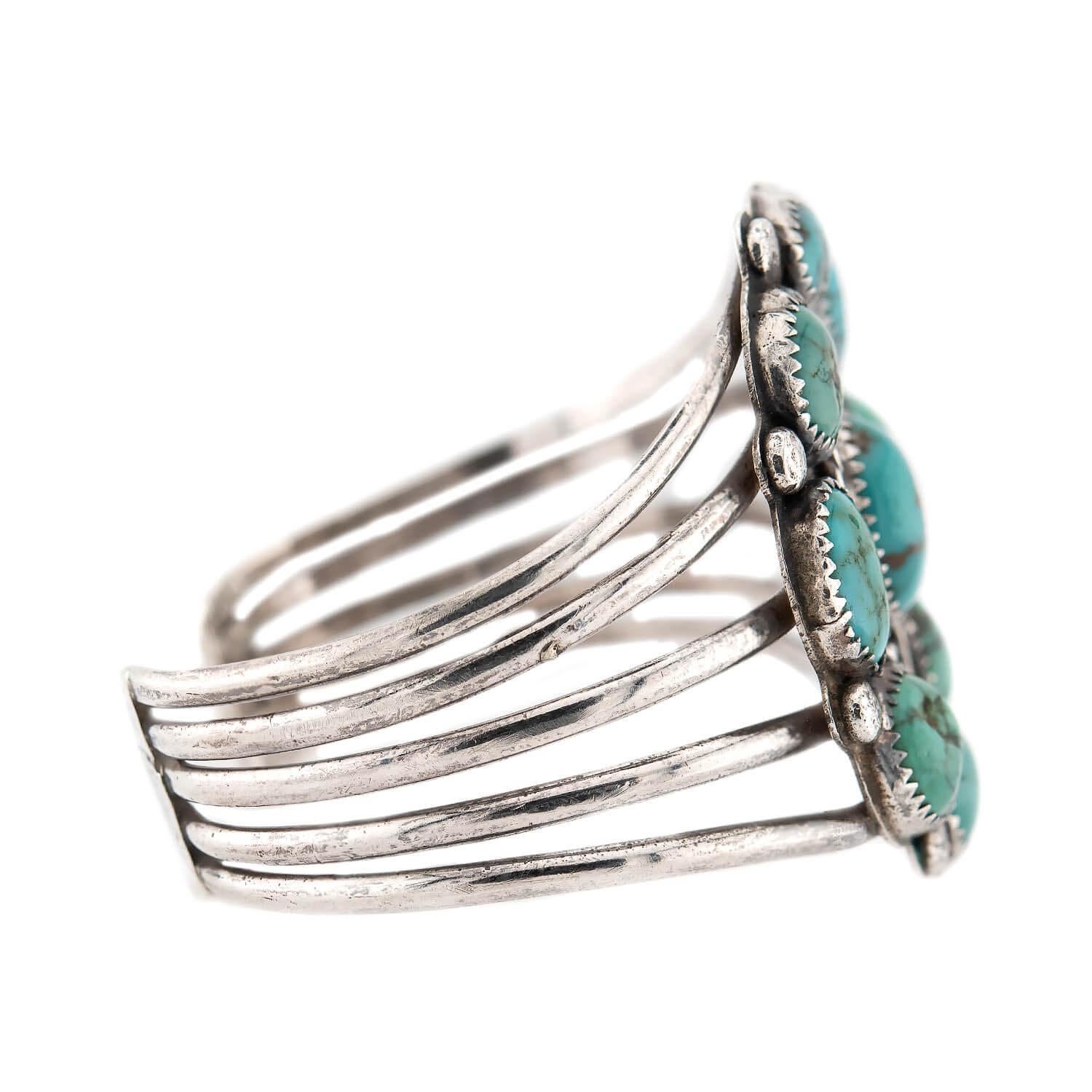 ¡Un fabuloso brazalete de turquesa de los nativos americanos de la época Vintage (ca1960s)! Esta fabulosa pieza está elaborada en plata de ley y presenta nueve piedras de turquesa sujetas en biseles con garras. Las piedras están dispuestas para