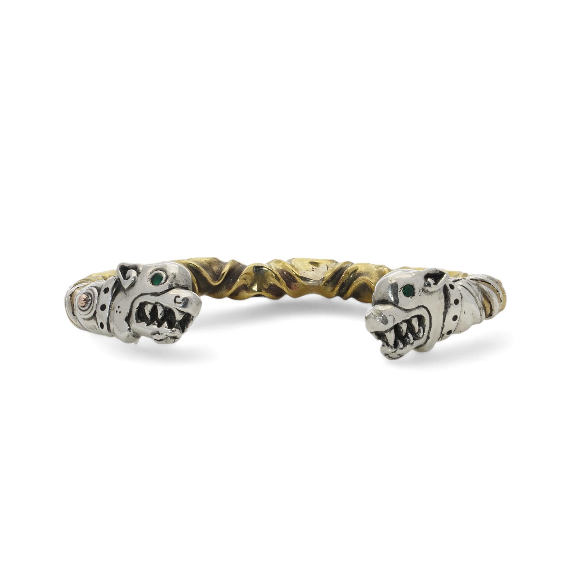 Vintage sterling silver open cuff bracelet with dog heads.

The twisted design incorporate gold-tone accents particularly noticeable along the band.
Each end of the bangle features a dog’s head, sculpted with intricate detail. The heads include