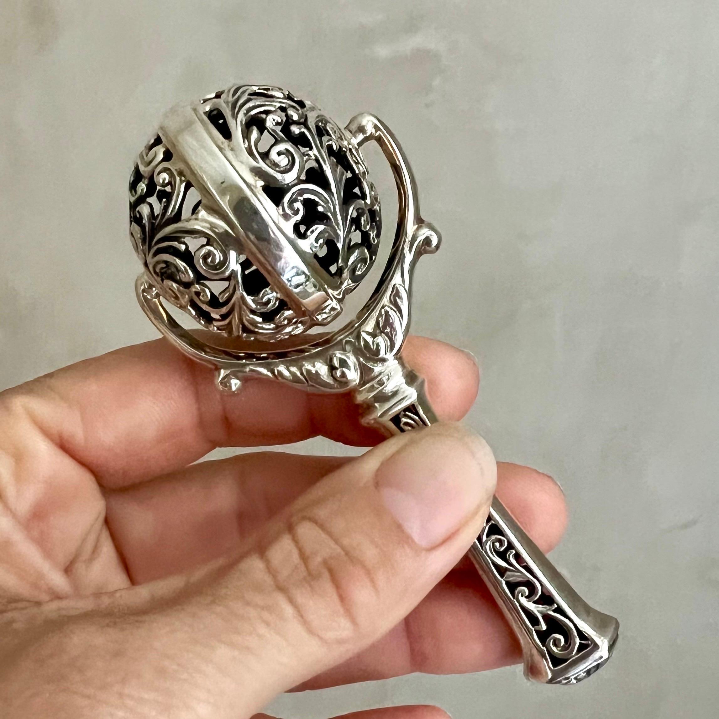 Diese Vintage-Babyrassel aus Sterlingsilber hat ein wunderschönes durchbrochenes Design mit einer sich drehenden Kugel. Die robuste, erstklassige Silberrassel ist aufwendig gestaltet, mit einem durchbrochenen Griff und einer großen drehbaren Kugel