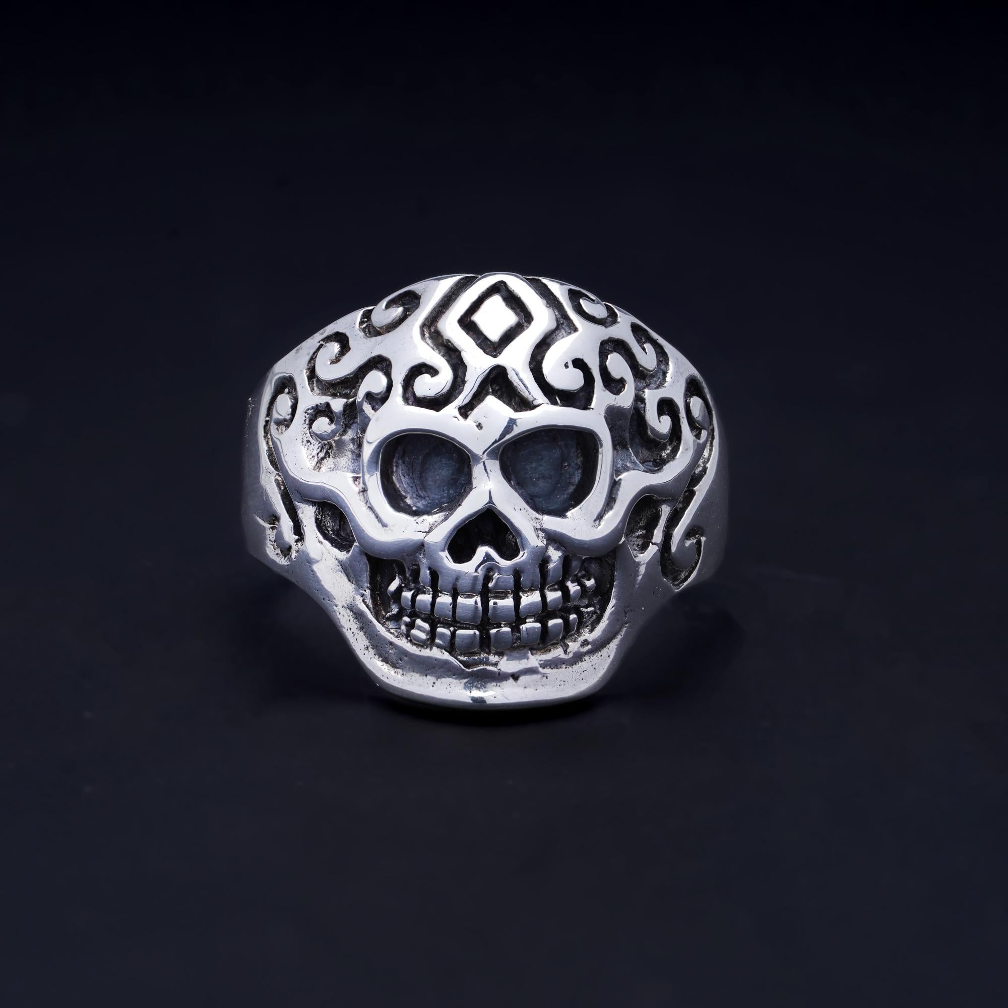 Vintage sterling silver ornate skull ring. 
Made In England, After 2000. 
Hallmarked 925

Dimensions -
Finger Size (UK) = T(US) = 9 3/4 (EU) =61 1/2
Size: Size: 2.8 x 2.2 x 2 cm 
Weight: 8.00 grams

Condition: Pre-owned, has some wear from general