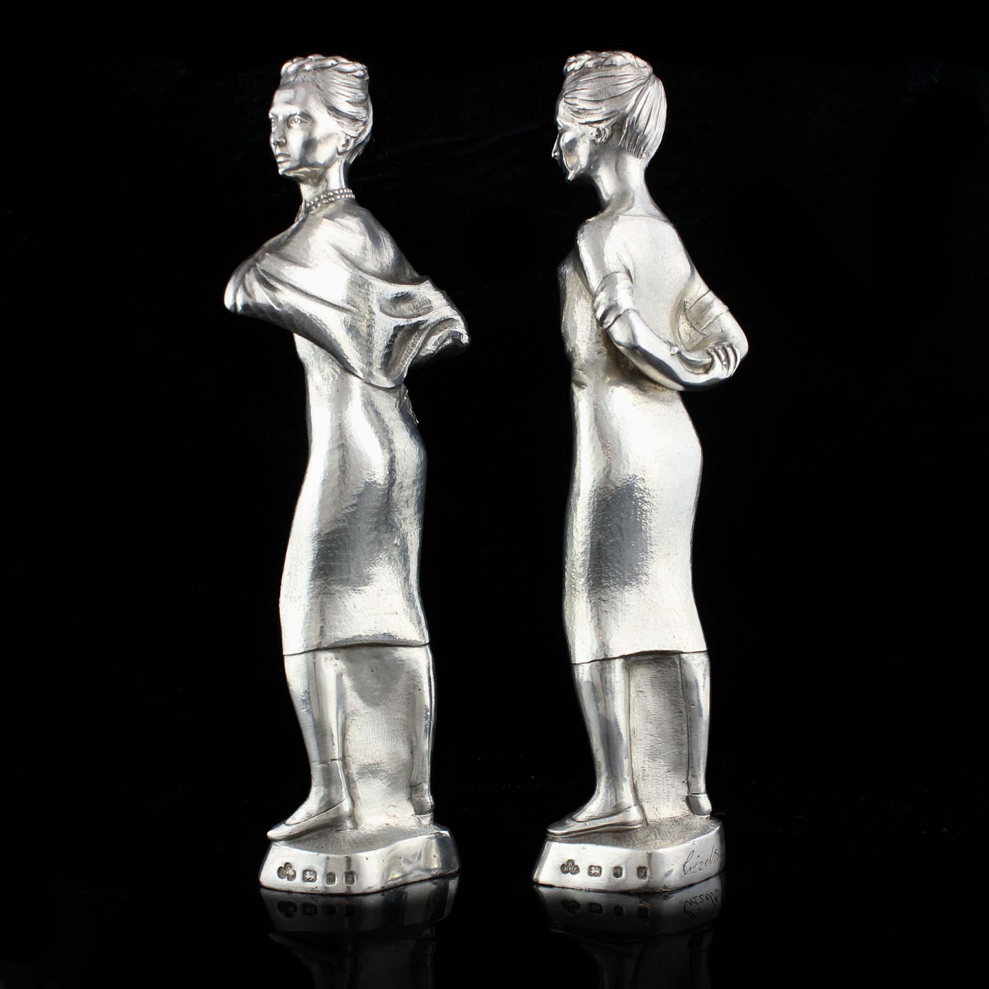 Vintage sterling silver pair of candlesticks in the shape of a two ladies.

Made in England, London, 1962
Maker: Nayler Brothers
Fully hallmarked.

Dimensions:
1st candlestick length x width x height 5.6 x 4.2 x 22.2 cm
2nd candlestick