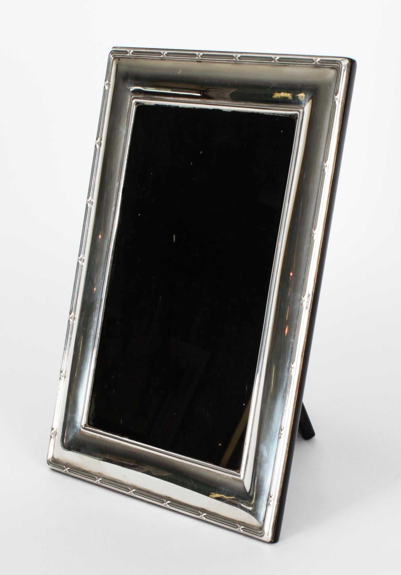 A truly superb decorative sterling silver photo frame with hall marks for Carr's of Sheffield, with the date mark for 1996.

The frame is beautifully decorated with reed and stitchborders and can be used landscape or portrait.

An excellent gift
