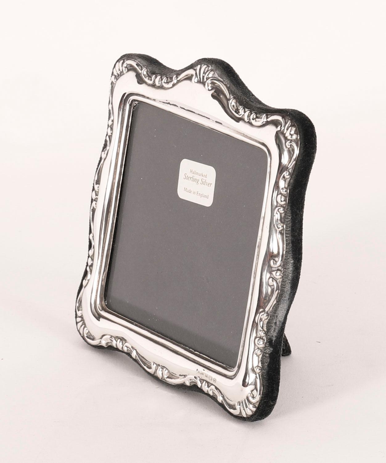 Una splendida cornice decorativa in argento sterling con il marchio di fabbrica P J Panton e i timbri di Birmingham 1990.

Bellissima cornice quadrata per ritratti, decorata con bordi a volute 's' e con un retro a cavalletto in velluto