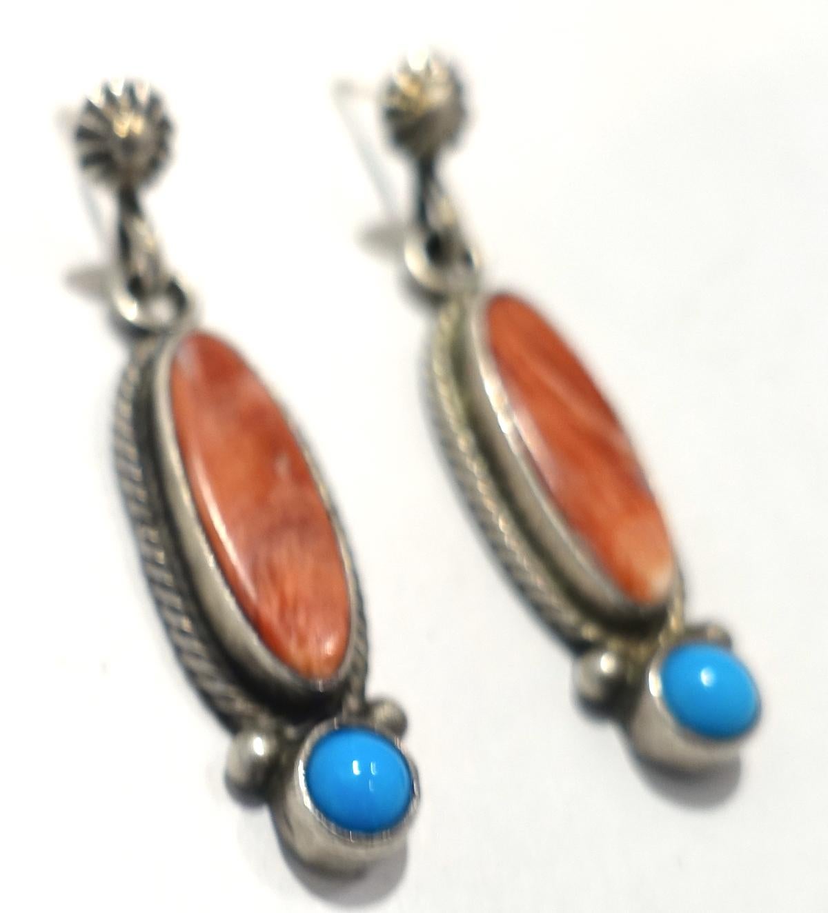 These vintage signed RB earrings has a coral color stone center encased in a sterling silver border.  A turquoise cabochon stone is at the bottom. In excellent condition, these pierced earrings measure 1-1/2” x 3/8” and are signed “RB 925”.