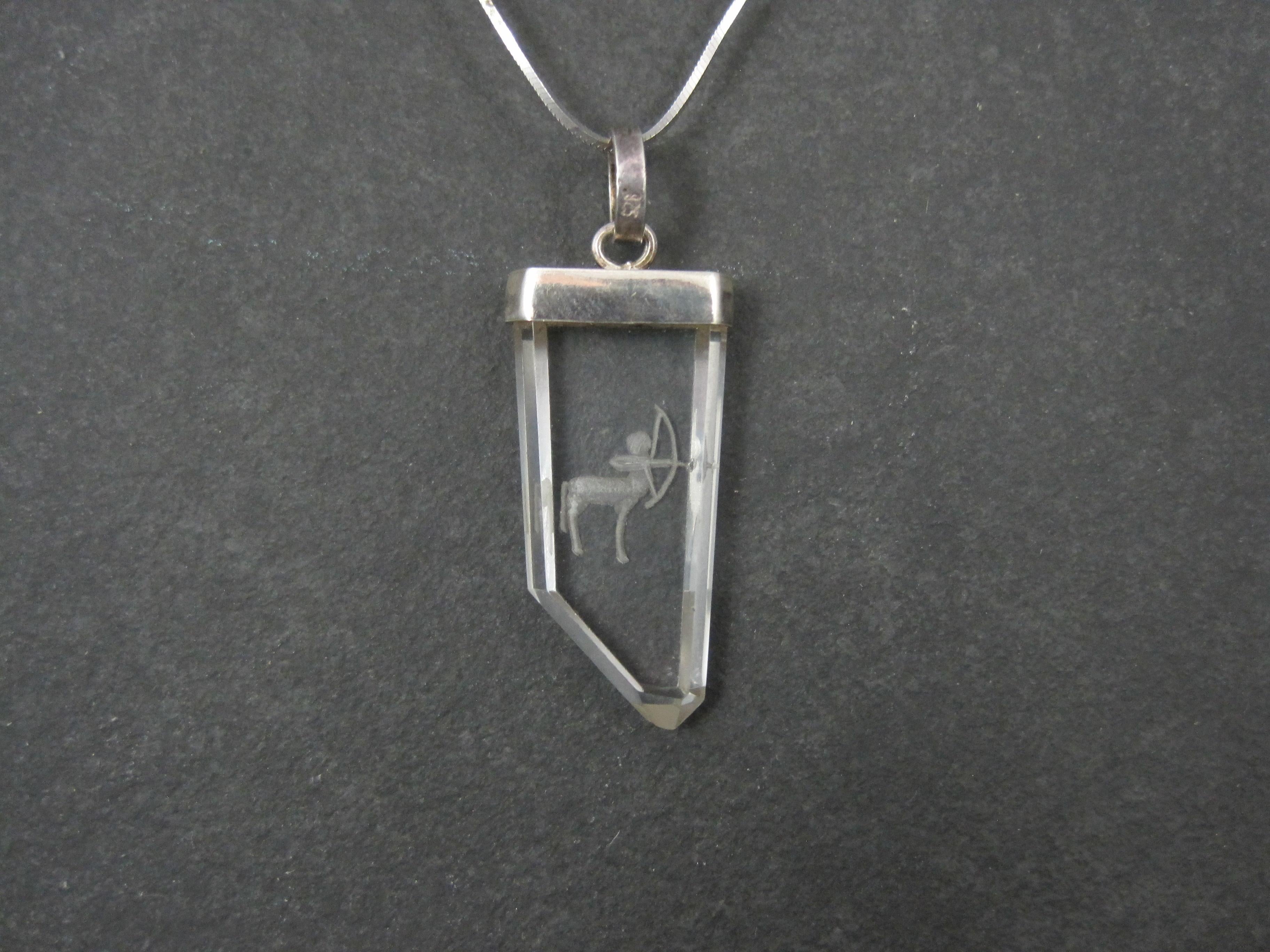 This gorgeous vintage pendant is sterling silver.
It features Sagittarius in intaglio on clear quartz.
The pendant measures 5/8 by 1 3/4 inches, including the bail.
It comes on a sterling silver, 18 inch chain.
Condition: Excellent with patina