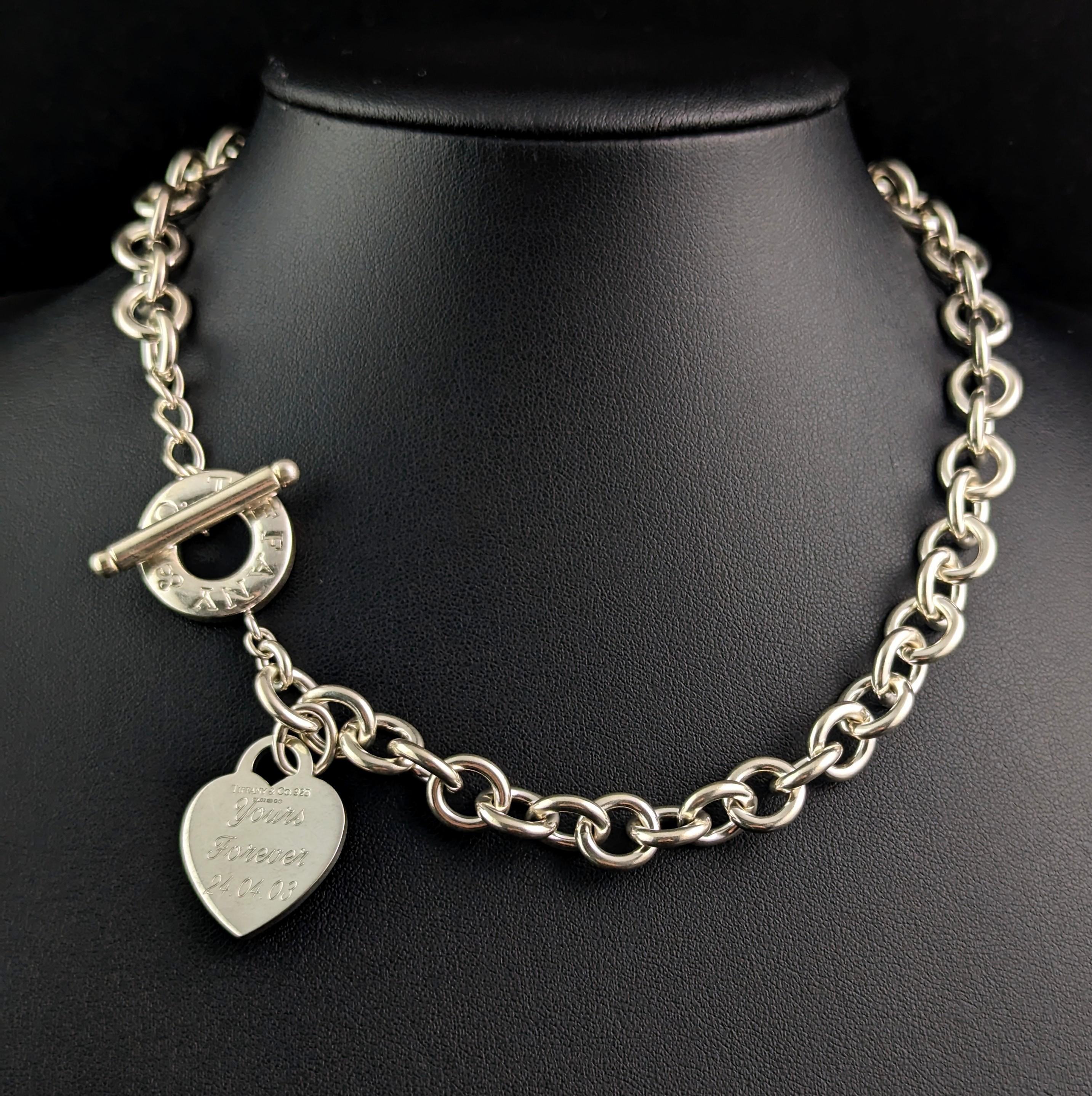 Un collier iconique en argent sterling vintage Return to Tiffany avec une étiquette en forme de cœur.

Il s'agit d'un collier ras-de-cou à maillons imbriqués de style rolo en argent sterling.

Le collier à bascule en forme de cœur est l'un des