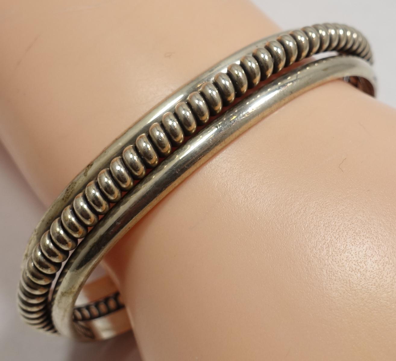 This vintage sterling silver cuff bracelet has smooth silver on the outside and a beautiful ribbed design in the middle. The cuff is adjustable and measures 6-1/2” x 3/8” and is in excellent condition.