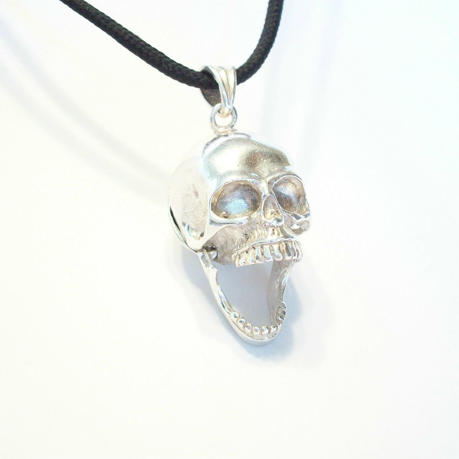 Vintage sterling silver skull pendant with hinged jaw and secret compartment - unsigned  - country of origin unkown - late 20th century.

Excellent vintage condition - no loss - no damage - no repairs - minor tarnishing & fine surface scratches with