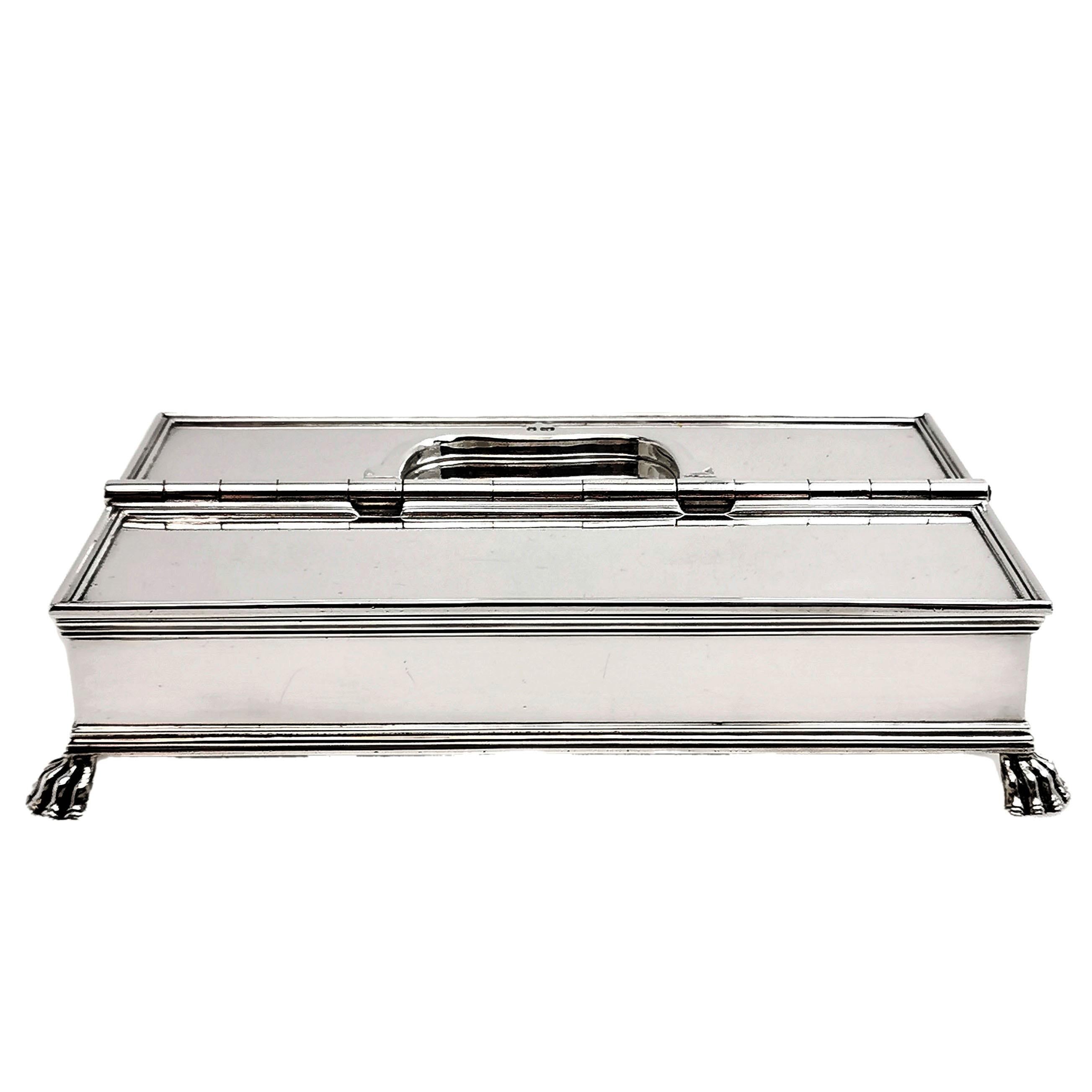 An elegant sterling Silver Inkstand in the classic 'Treasury' style from the Queen Anne Period. This Rectangular Inkstand has two compartments with hinged lids. The one has a pair of glass inkwells on either side of an empty storage compartment,