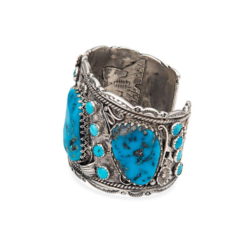 This beautiful and unique vintage sterling silver cuff features four large turquoise stones accented by sixteen round turquoise stones. The entire cuff features very intricate and detailed hand engraving, floral details and scalloped edges. This