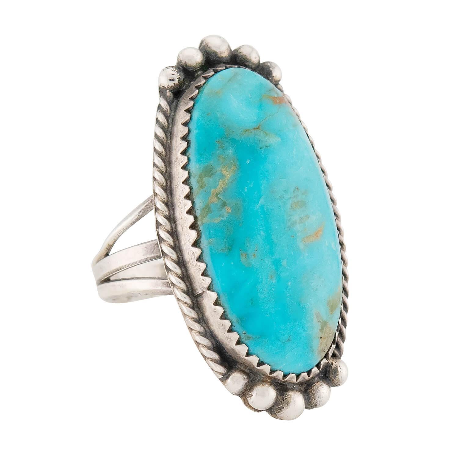 A gorgeous turquoise ring from the Vintage era (ca1960s) era! This wonderful piece displays a beautiful turquoise stone that is bezel set at the center of a substantial sterling silver centerpiece. The elongated turquoise stone is oval in shape and