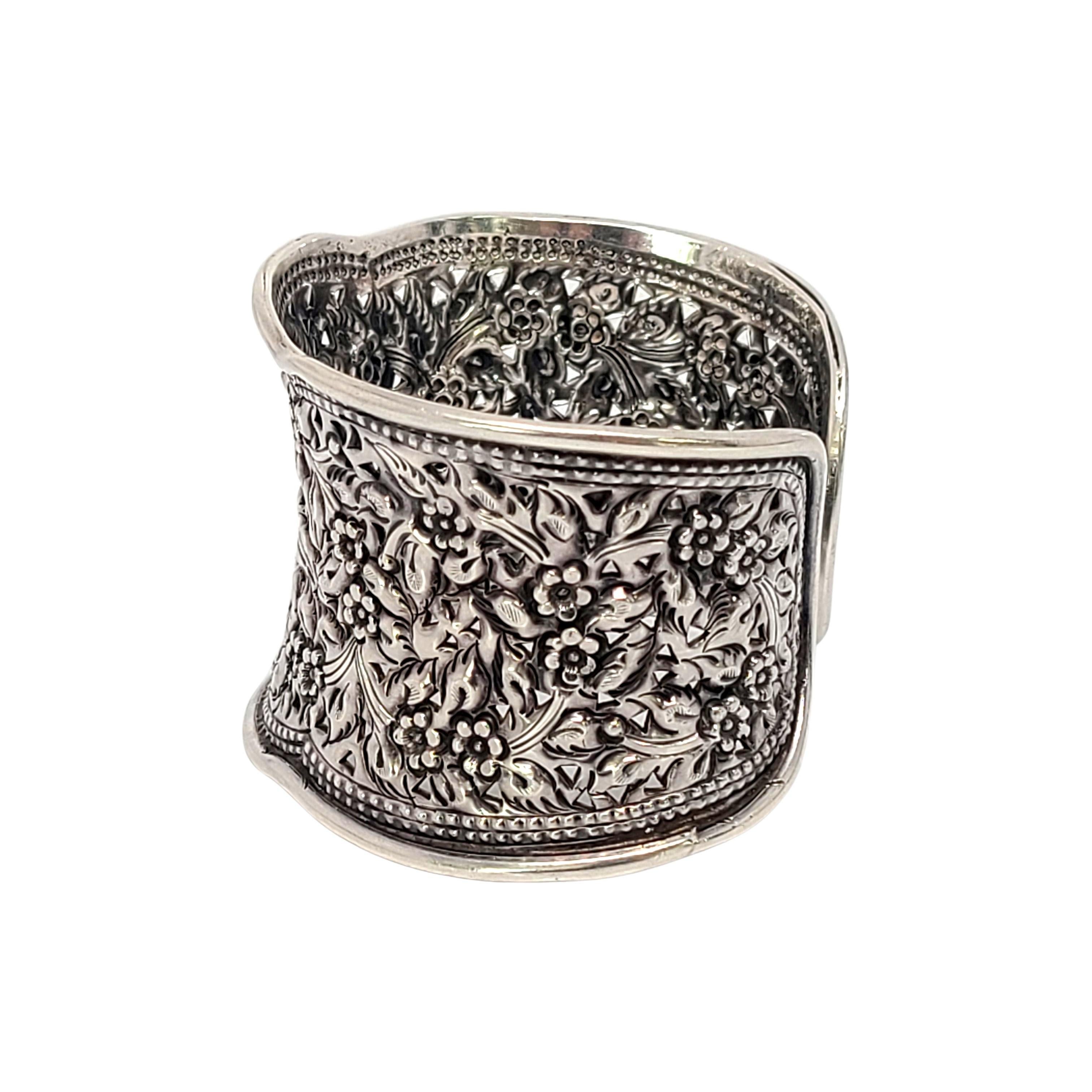Sterling silver wide floral design cuff bracelet.

Beautiful repousse flower and leaf design with small cut-outs.

Measures approx 6 1/2