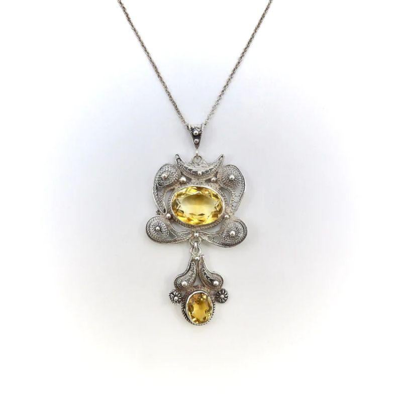 This is a gorgeous vintage sterling silver and citrine pendant necklace that features beautifully intricate sterling silver wirework with tightly-wound, braid-like detailing, molded into various three-dimensional shapes and accented with beading.