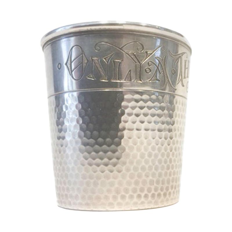 Mid-Century Modern sterling silver jigger in the form of a thimble with gold washed interior. The thimble has an all-over dimpled surface with a smooth band at the top which in engraved with the words 