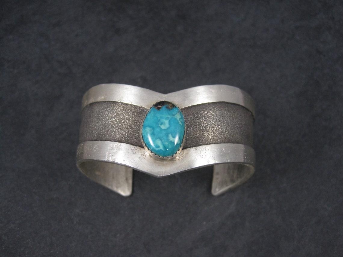 This amazing tufa cast bracelet is sterling silver.
It features a natural 17x13mm turquoise stone.

This bracelet measures 1 inch wide and is done in the traditional 