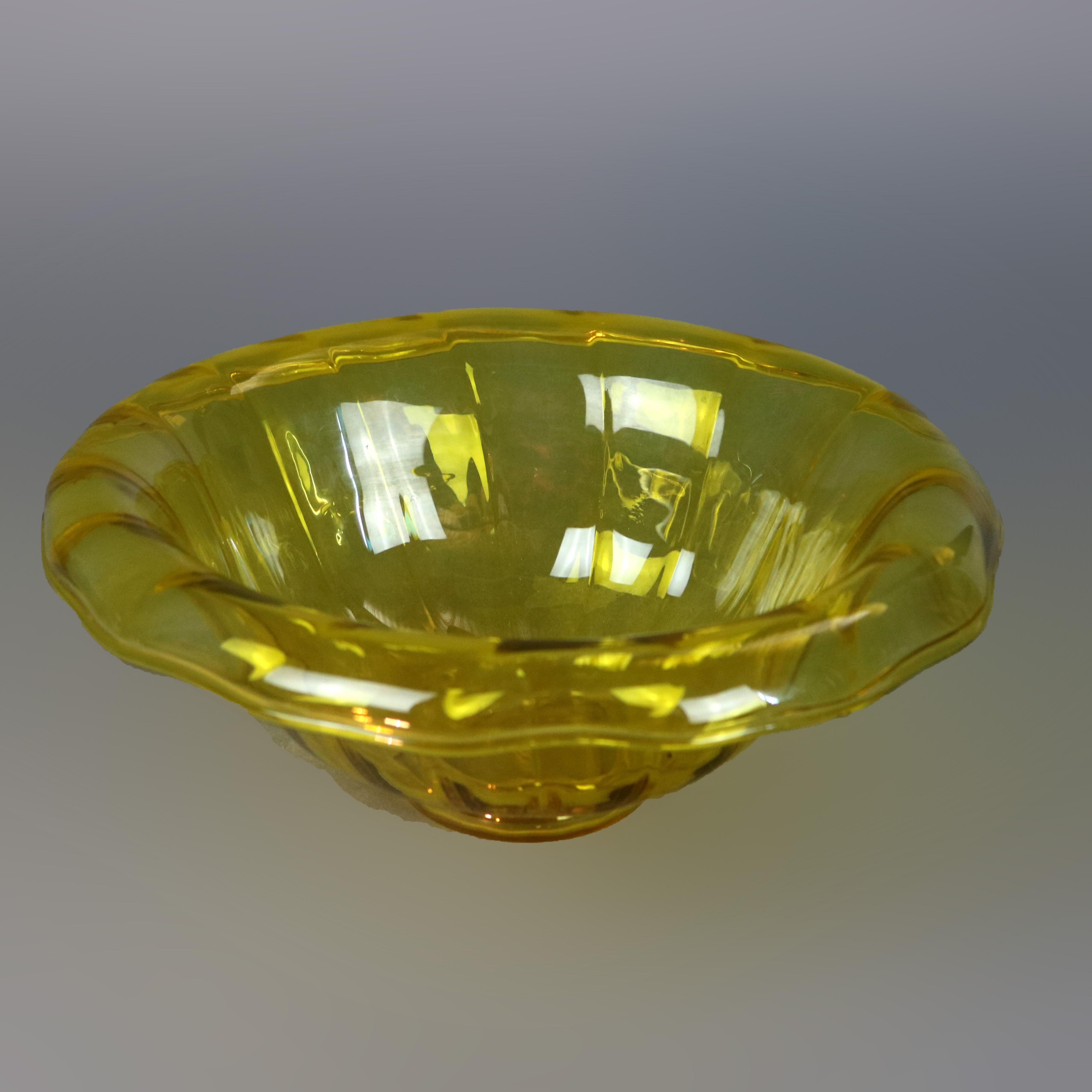 A vintage center bowl by Steuben offers amber art glass construction with paneled bowl and wide scrolled rim, unsigned, 20th century.

Measures: 4.5