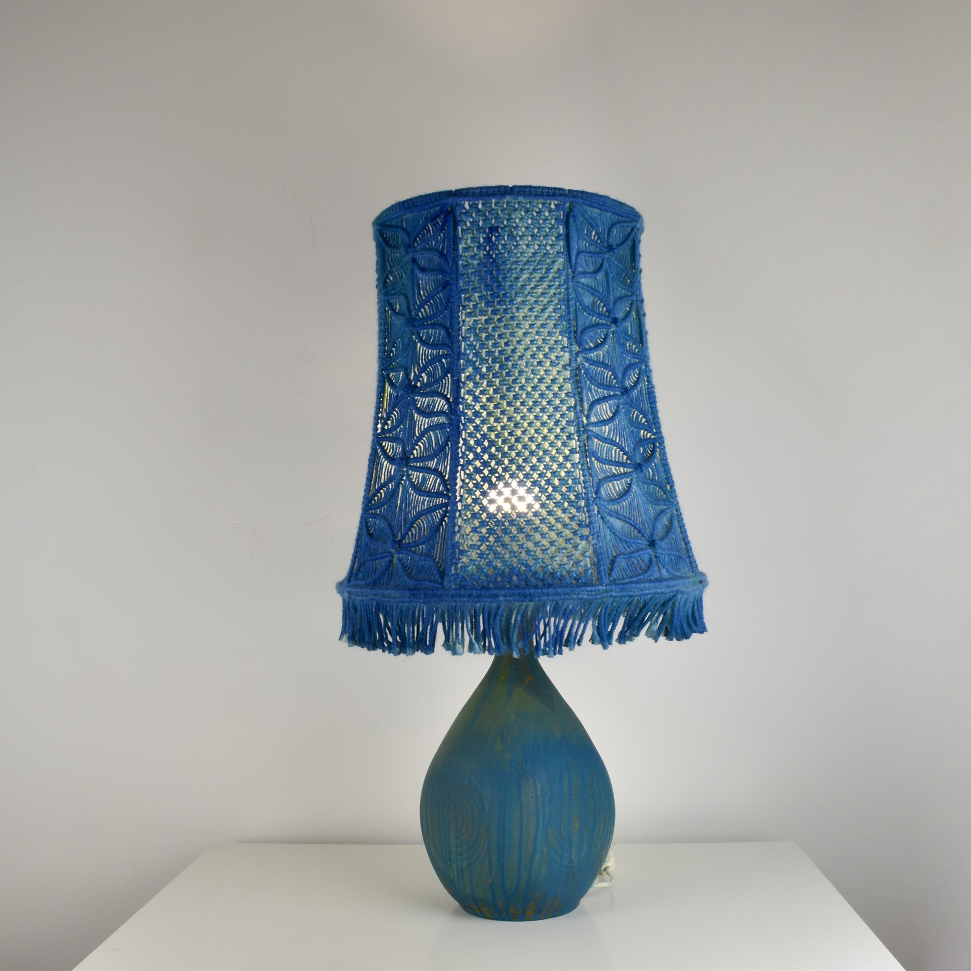 Questa lampada vintage combina una base in ceramica che ricorda l'iconico stile scandinavo di Stig Lindberg con un esclusivo paralume in macramè fatto a mano dalle suggestive tonalità blu. 
La base della lampada è caratterizzata da smalti organici e