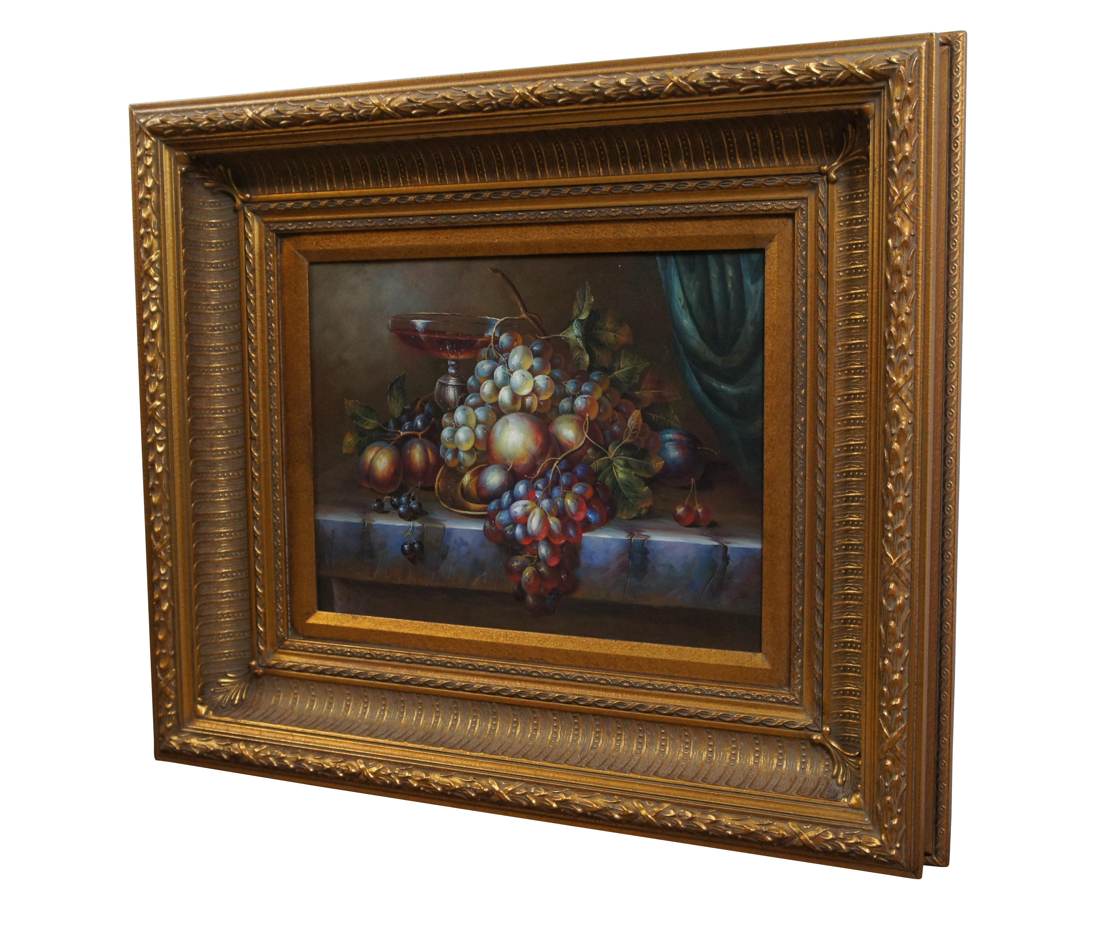Late 20th century oil painting on canvas featuring a still life of grapes, peaches and plums and a goblet of wine on a stone table. Displayed in an elegantly carved gold gesso frame.

Dimensions:
26.75