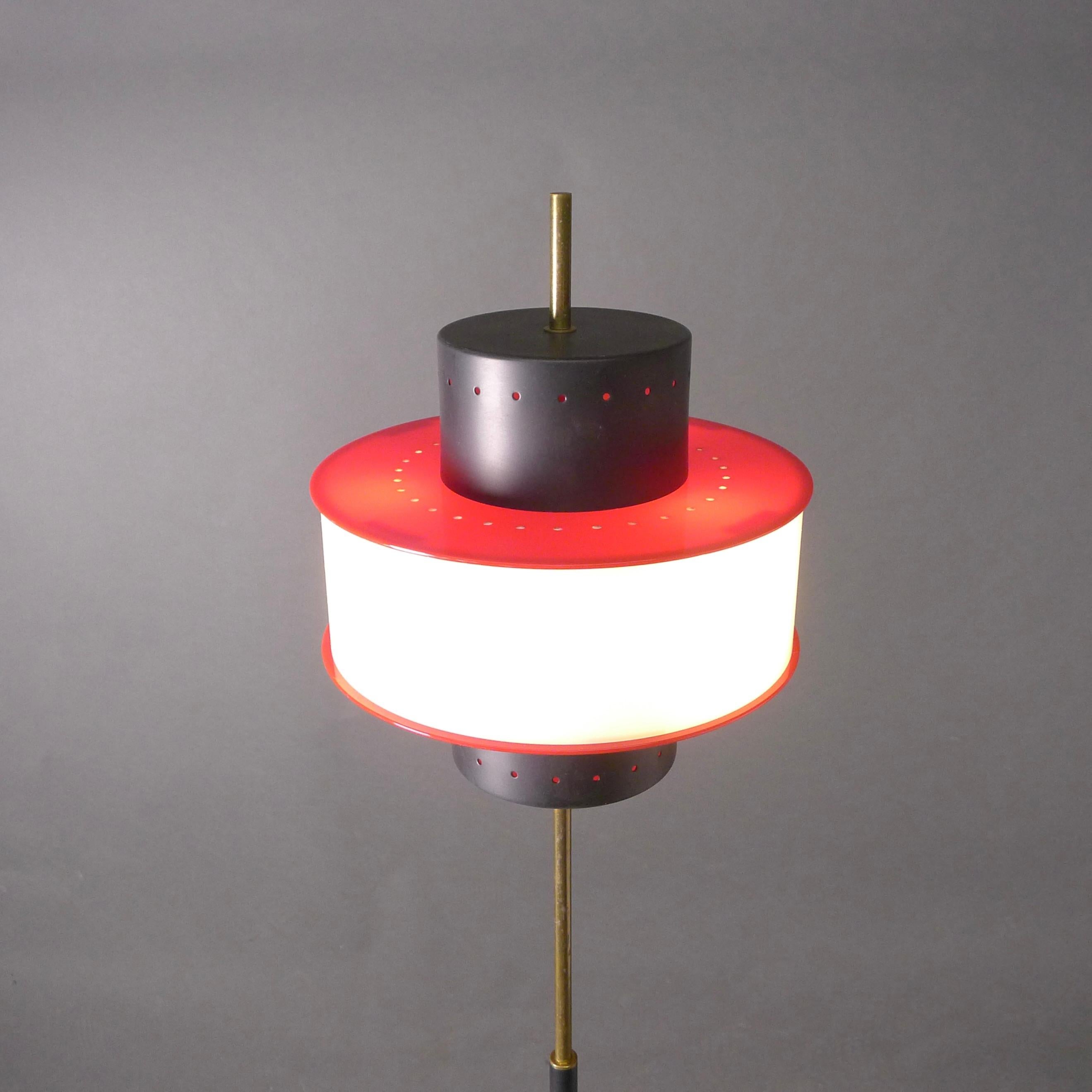 Stilnovo mid-century vintage floor lamp in black, white and red.

This elegant Stilnovo floor lamp comprises a black enamelled metal cylindrical shade surrounded by a white and red plexiglass diffuser, all with tiny perforations creating a soft