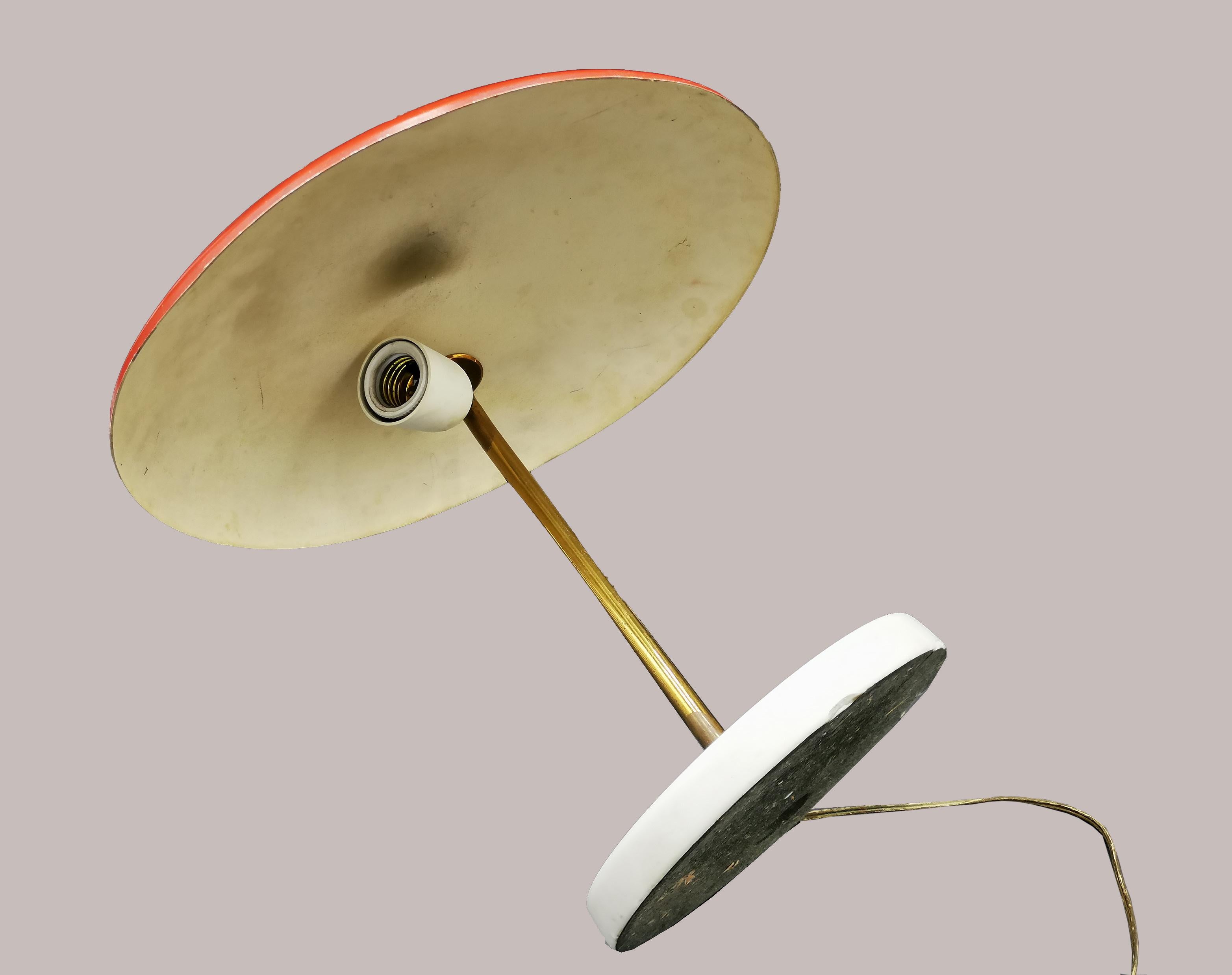 This vintage Stilnovo table lamp is a design lamp manufactured by Stilnovo during the second half of the 20th century.

Table or desk lamp - model D 5120 - characterized by simple and clean lines. Arm in brass, reflector bulb in red enameled
