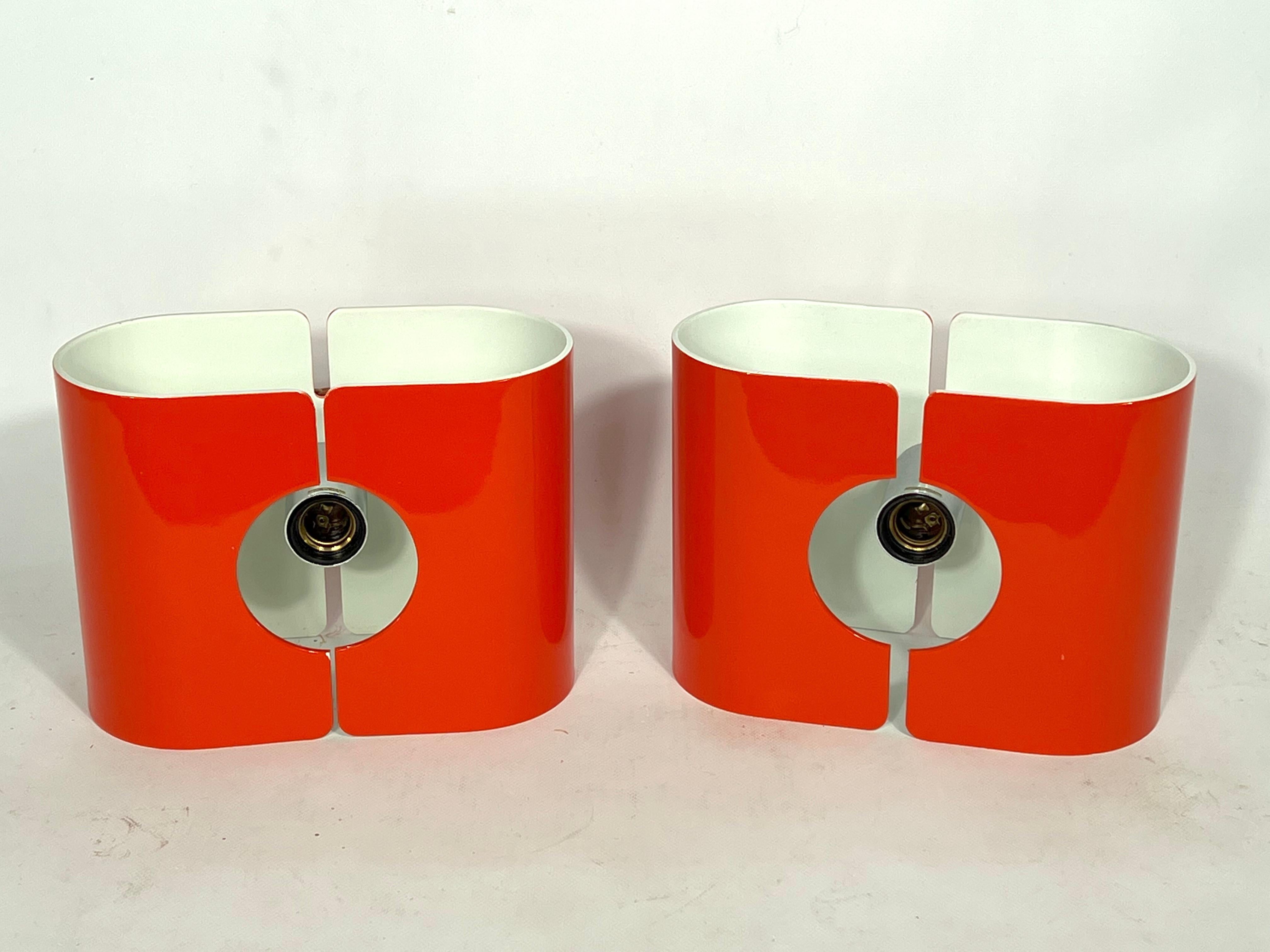 Great condition for this set of two orange lacquered metal sconces produced by Stilux Milano during the 70s. Manufacturing Tag and label. Mendola model. Full working with EU standard, adaptable on demand for USA standard.