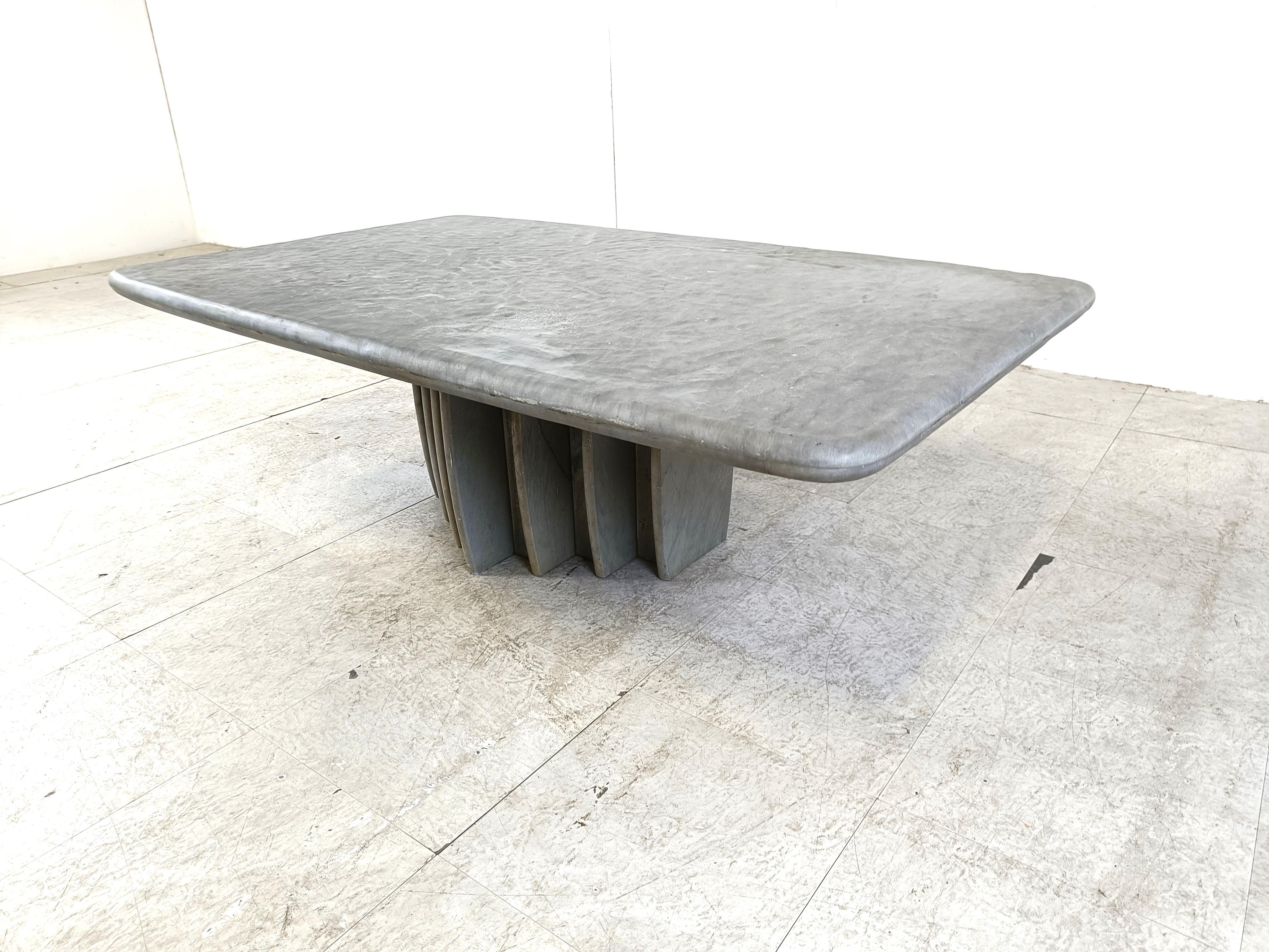 Beautiful coffee table with an architectural stepped stone base and a nice stone top.

We are not sure about the stone species, but it has a great 'rough' look to create a contrast with modern interiors.

1980s - Probably made in Italy

Good