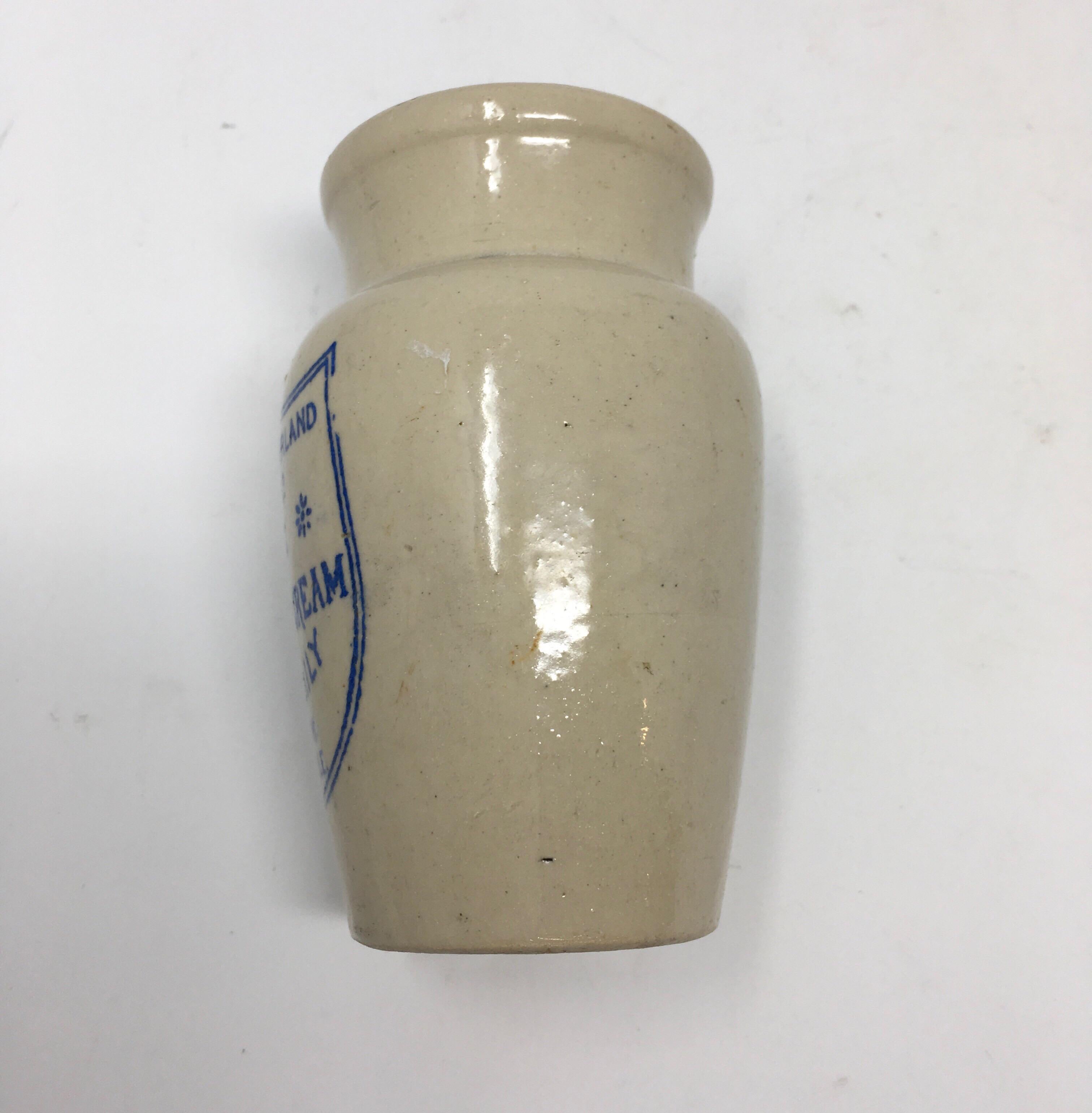 From Northwest England, this blue print pure thick cream pot from Cumberland is approximate 4.25 inches high and in good clean condition. The decorative pot is printed on the front in blue lettering under the glaze and has the company's logo, a
