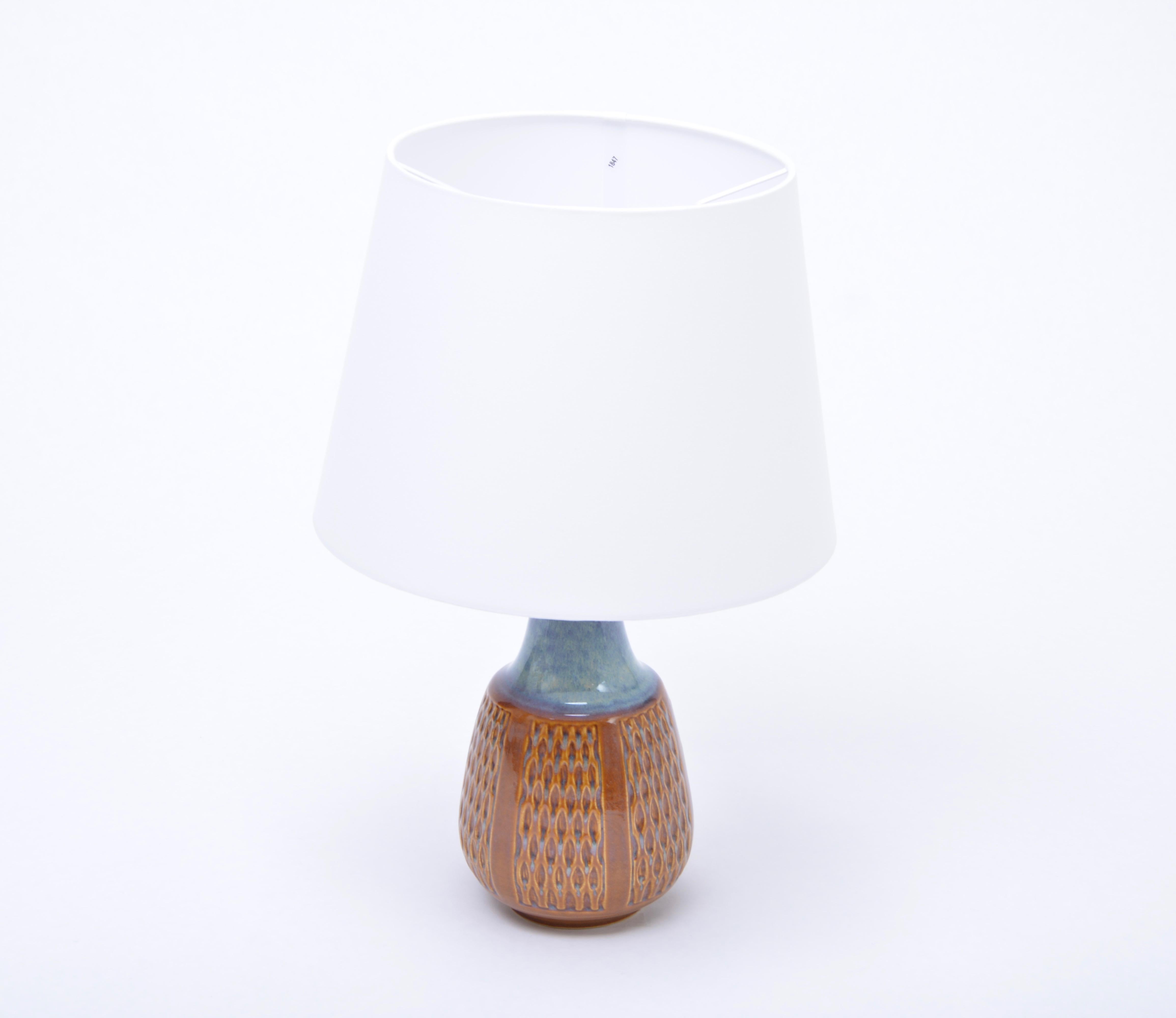 Mid-Century Modern Stoneware table lamp model 1002 by Einar Johansen for Soholm

Table lamp made of stoneware with ceramic glazing in different tones of brown and blue. Graphic pattern to the base of the lamp. Designed by Einar Johansen and produced